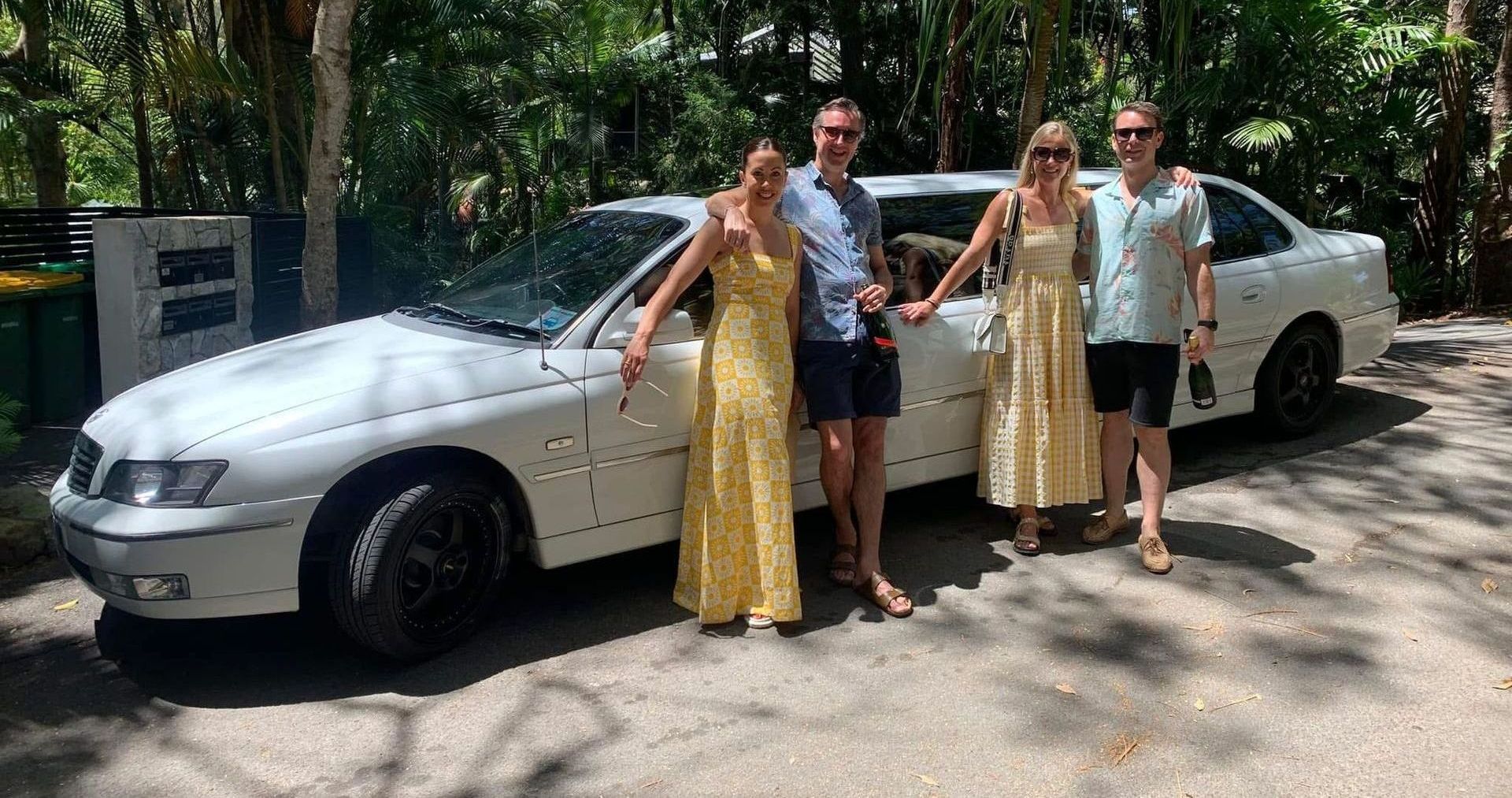 Family Standing In Front Of White Limousine, Smiling And Having Fun -Noosa Premier Stretch Holden Transfers In Sunrise Beach, QLD