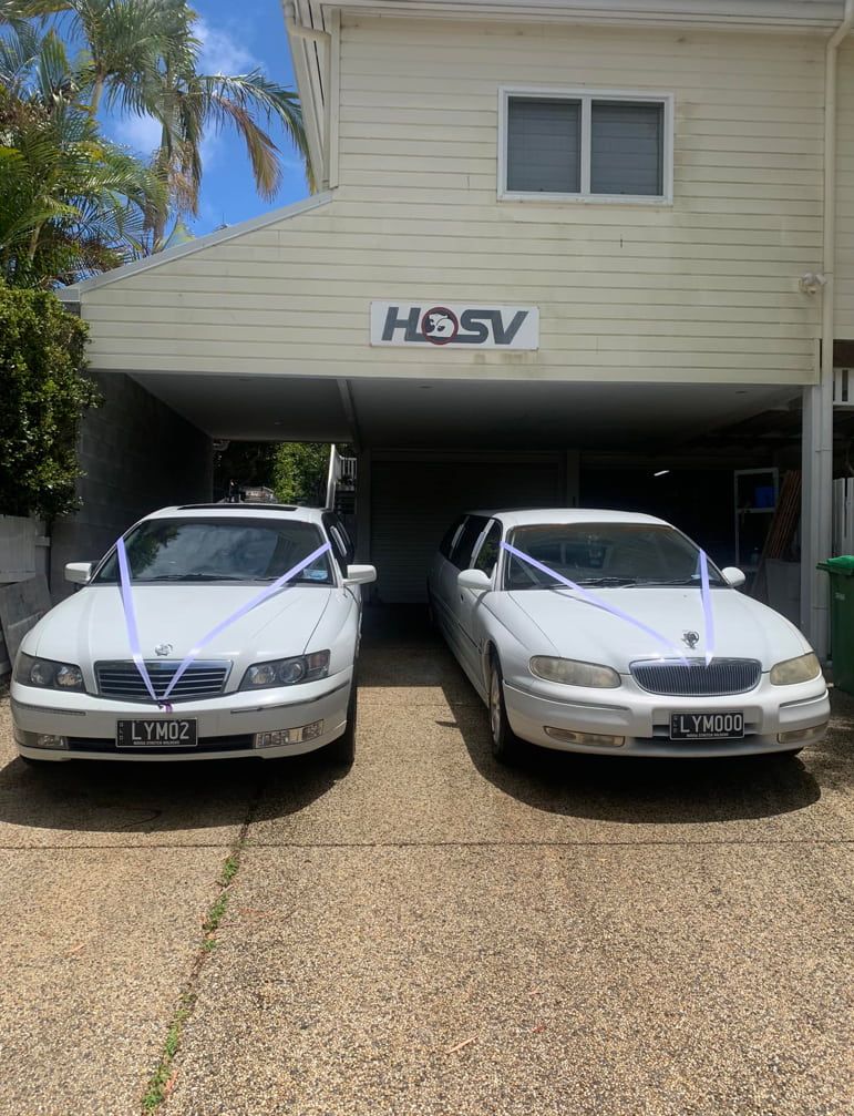 Two White Cars Are Parked In Front Of A House — Noosa Premier Stretch Holden Transfers In Sunrise Beach, QLD