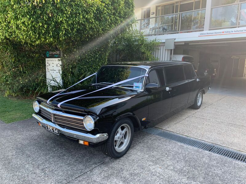 A Black Limousine Is Parked In Front Of A House — Noosa Premier Stretch Holden Transfers In Sunrise Beach, QLD