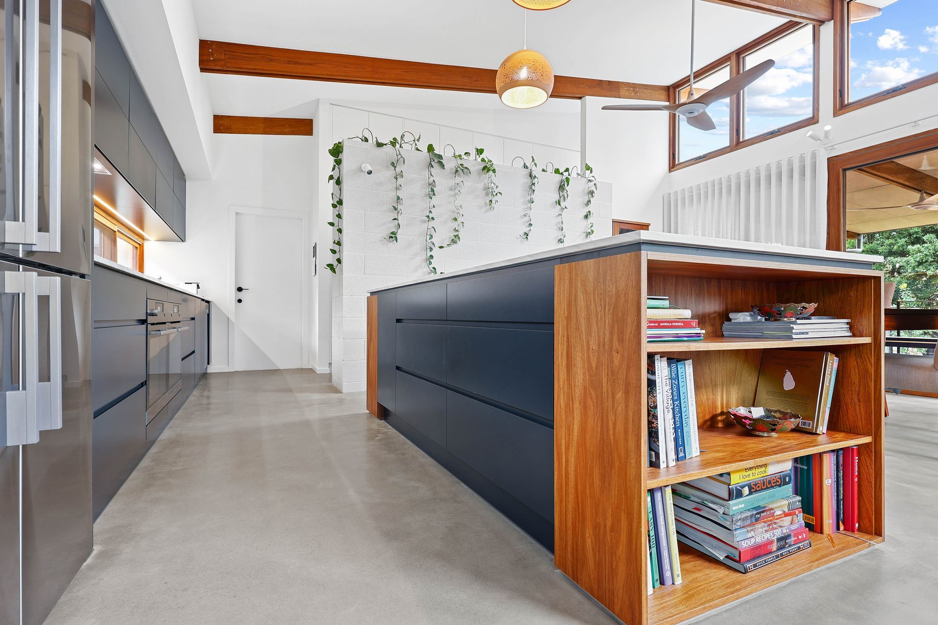 Modern kitchen with blue cabinets, wooden island, and large windows — Above & Beyond Interiors Custom Joinery in Bellambi, NSW
