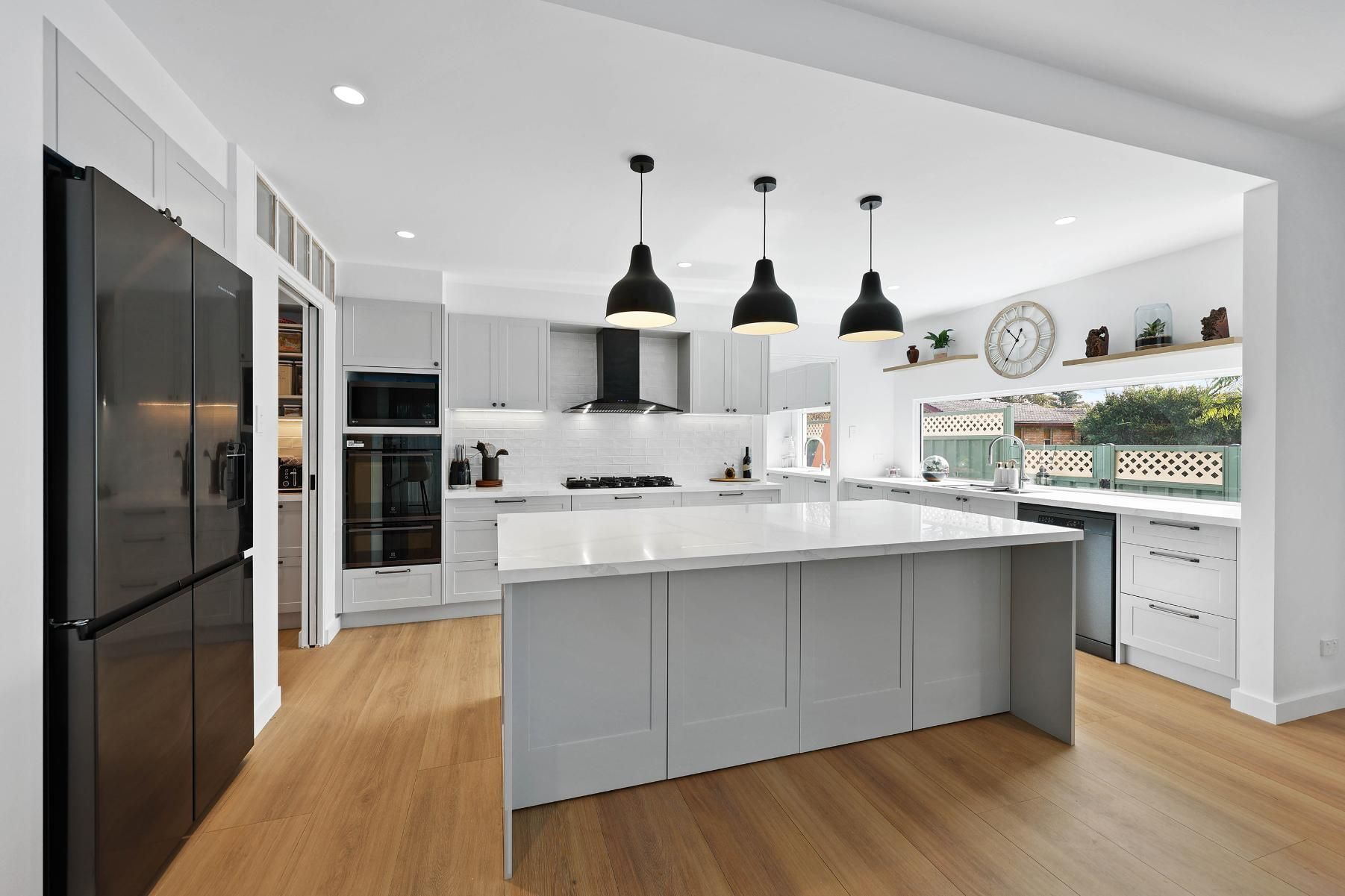 Modern Kitchen with Grey Cabinets, Island, Black Pendant Lights, and Stainless Appliances — Above & Beyond Interiors Custom Joinery in Yowie Bay, NSW
