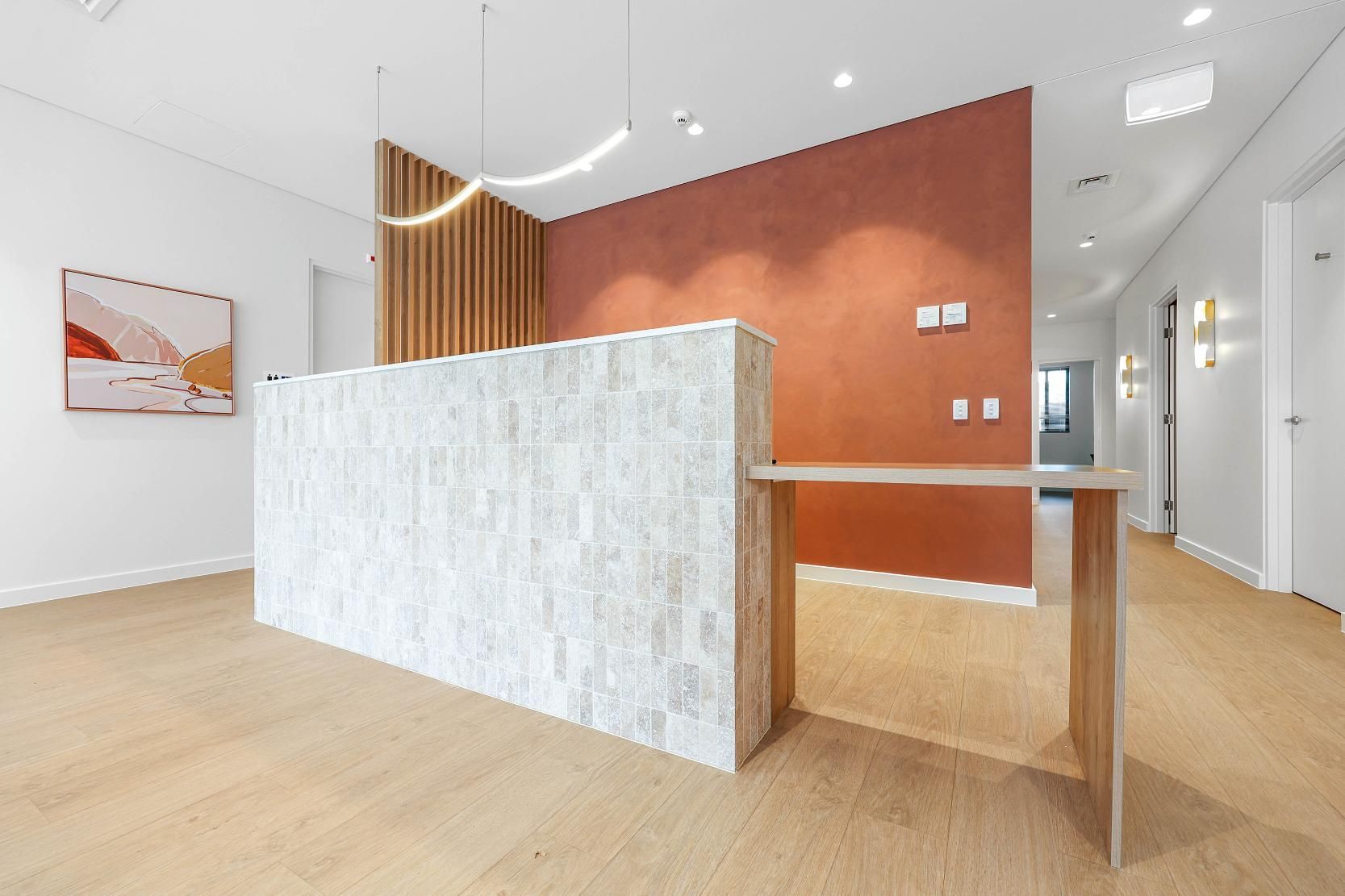Reception Area with Stone Front Desk, Wood Paneling, and Terracotta Wall — Above & Beyond Interiors Custom Joinery in Medical Centre, NSW