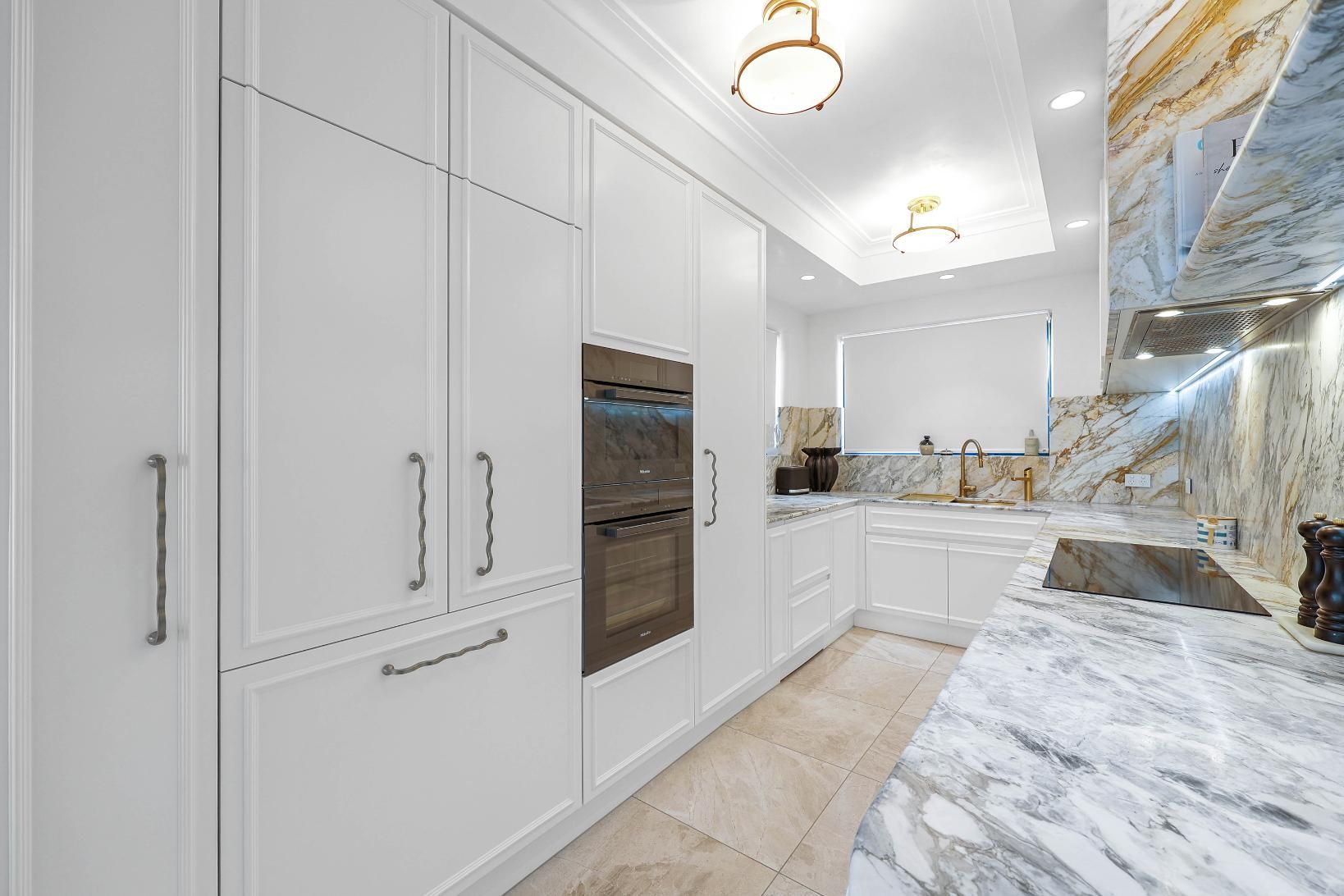 White Kitchen with Marble Countertops, Built-In Appliances, and Modern Cabinets — Above & Beyond Interiors Custom Joinery in Double Bay, NSW