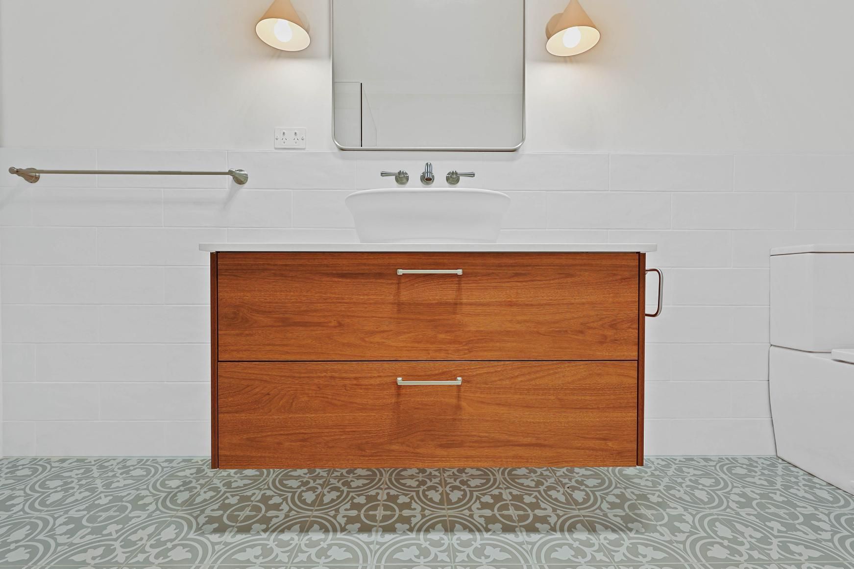 Floating Wooden Vanity with Two Drawers, a Mirror, and Patterned Floor Tiles in A Modern Bathroom — Above & Beyond Interiors Custom Joinery in Appin, NSW