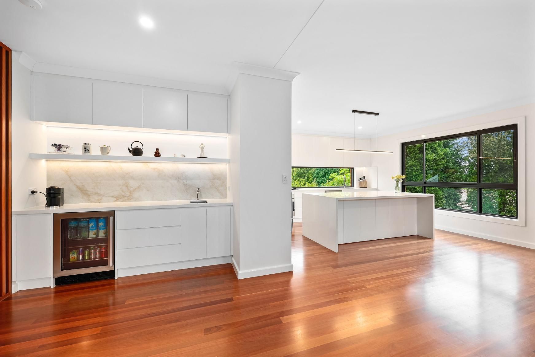 Modern White Kitchen with Built-In Bar, Hardwood Floors, and Large Windows Overlooking Trees — Above & Beyond Interiors Custom Joinery in Killara, NSW
