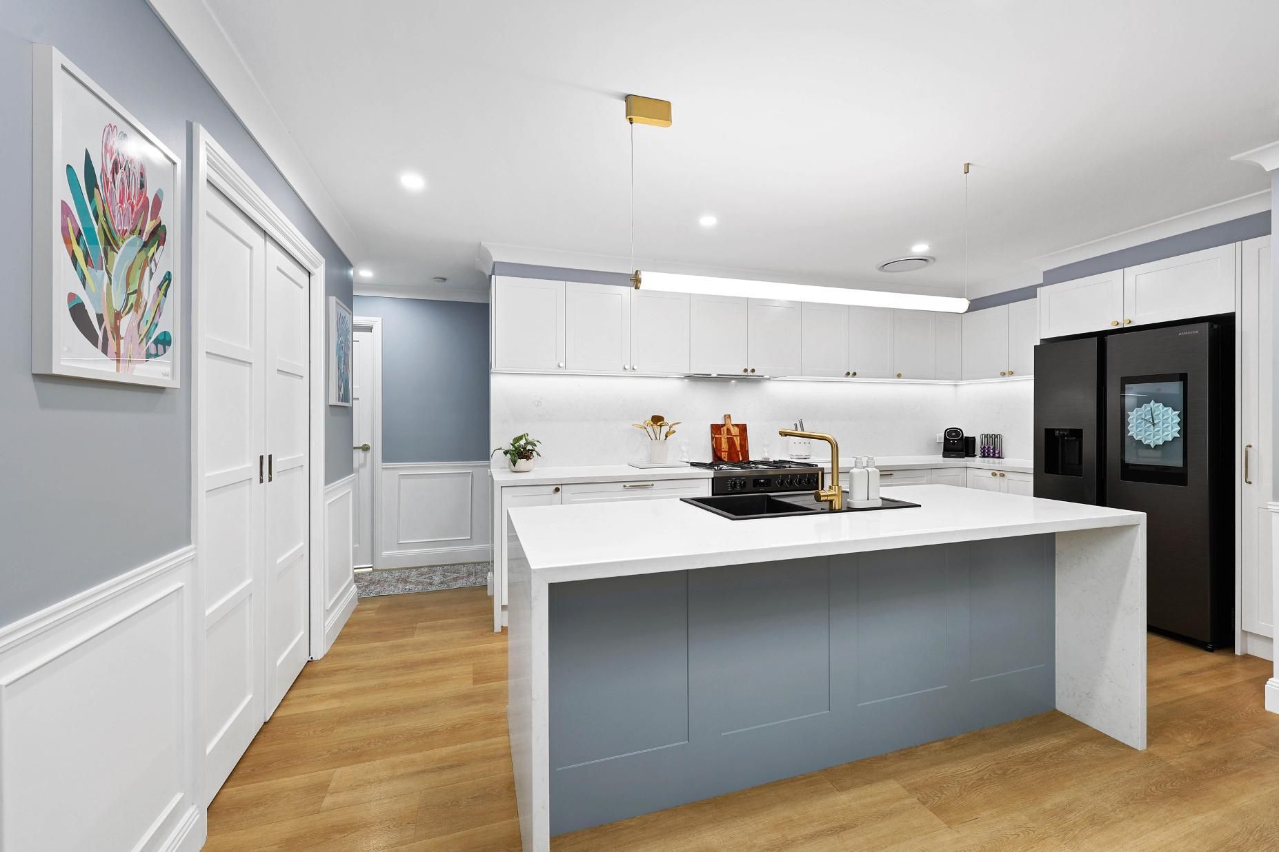 Modern Kitchen with White Cabinets, Blue Island, and Black Refrigerator — Above & Beyond Interiors Custom Joinery in Harrington Park, NSW