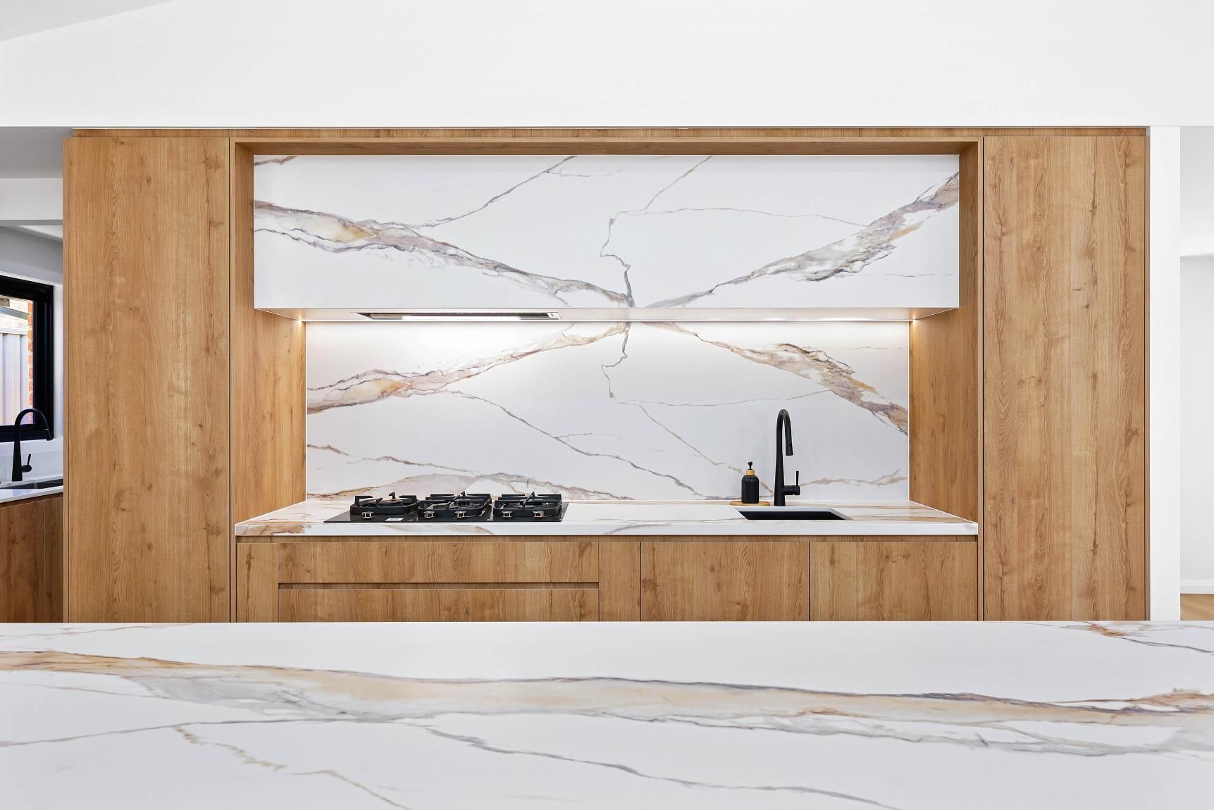 Modern Kitchen with Wood Cabinetry, Marble Backsplash, and Countertop — Above & Beyond Interiors Custom Joinery in Abbortsbury, NSW