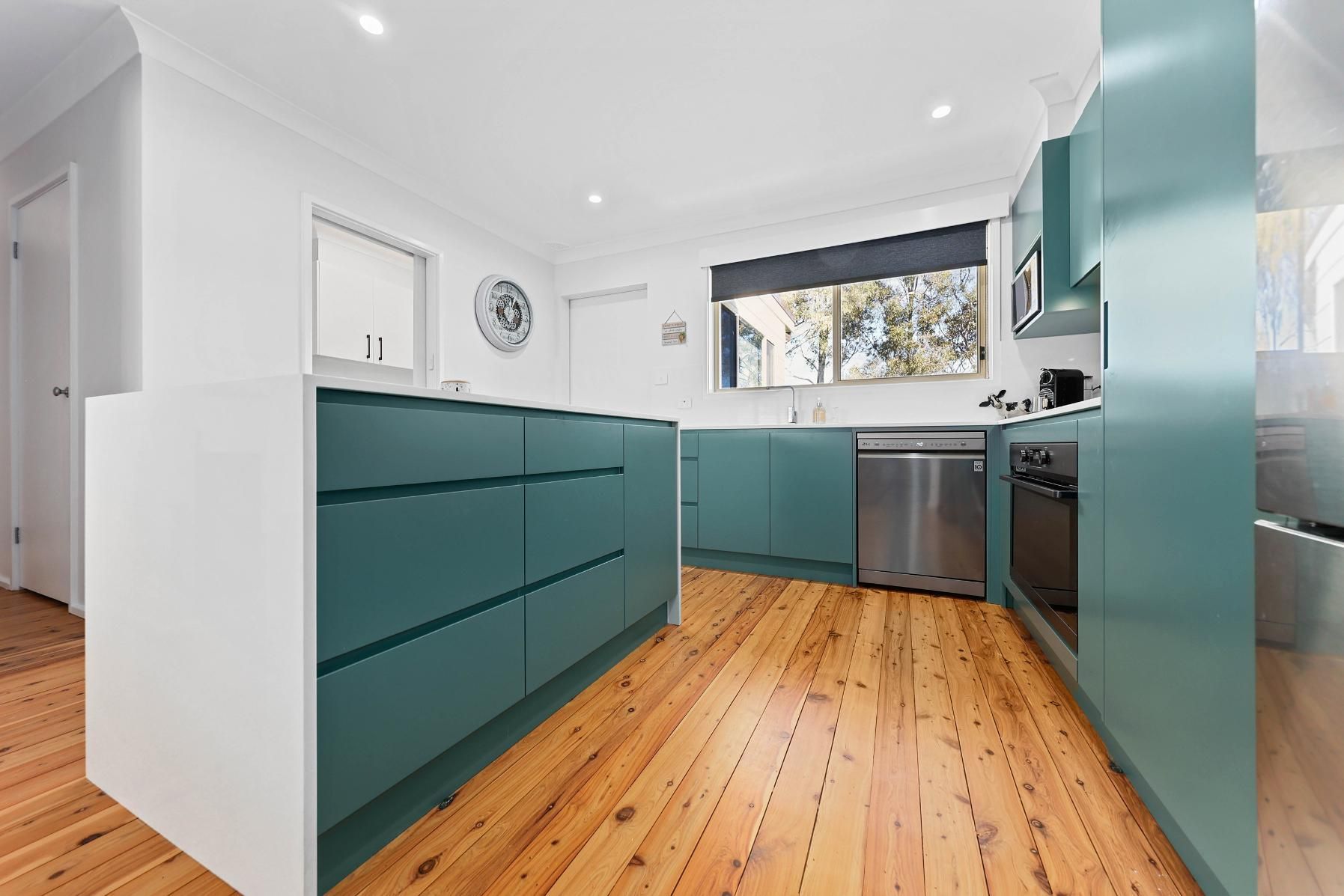 Modern Kitchen with Teal Cabinets, White Walls, and Wood Flooring — Above & Beyond Interiors Custom Joinery in Bradbury, NSW