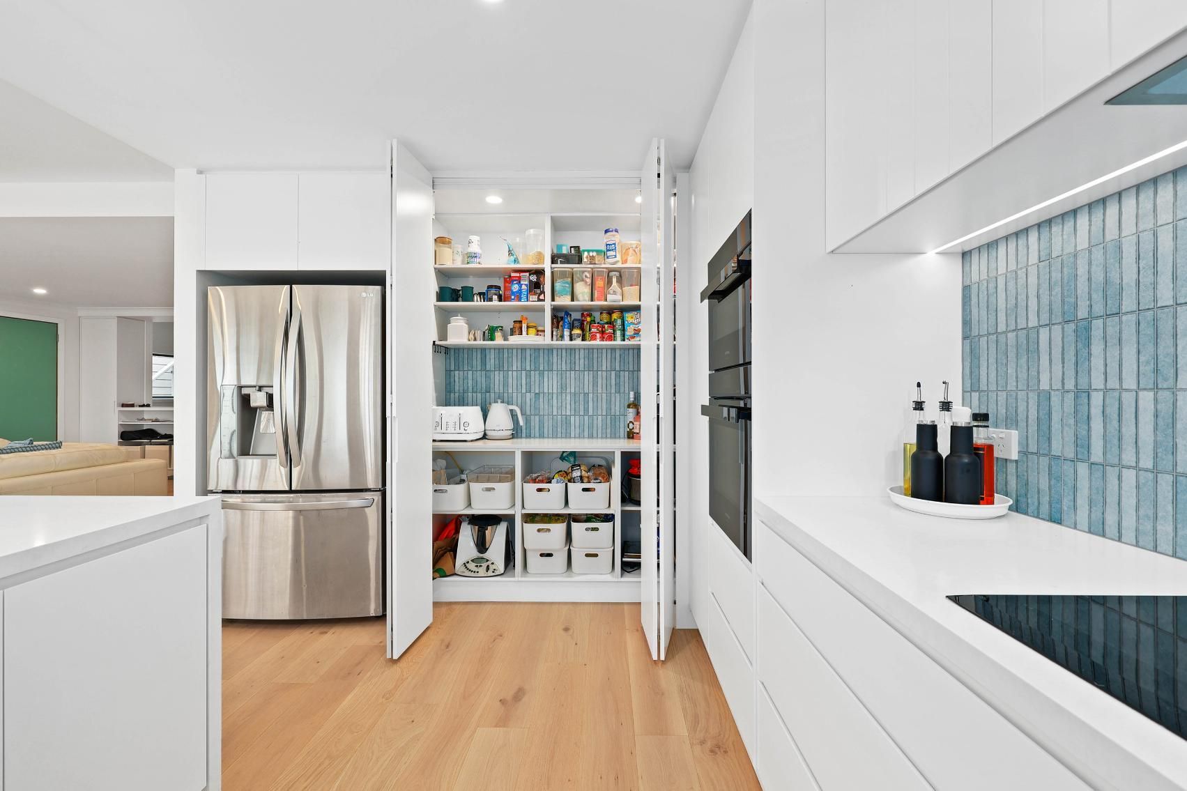 Modern White Kitchen with A Pantry; Wood Floors, Stainless Steel Fridge, Blue Tile Backsplash — Above & Beyond Interiors Custom Joinery in North Curl Curl, NSW