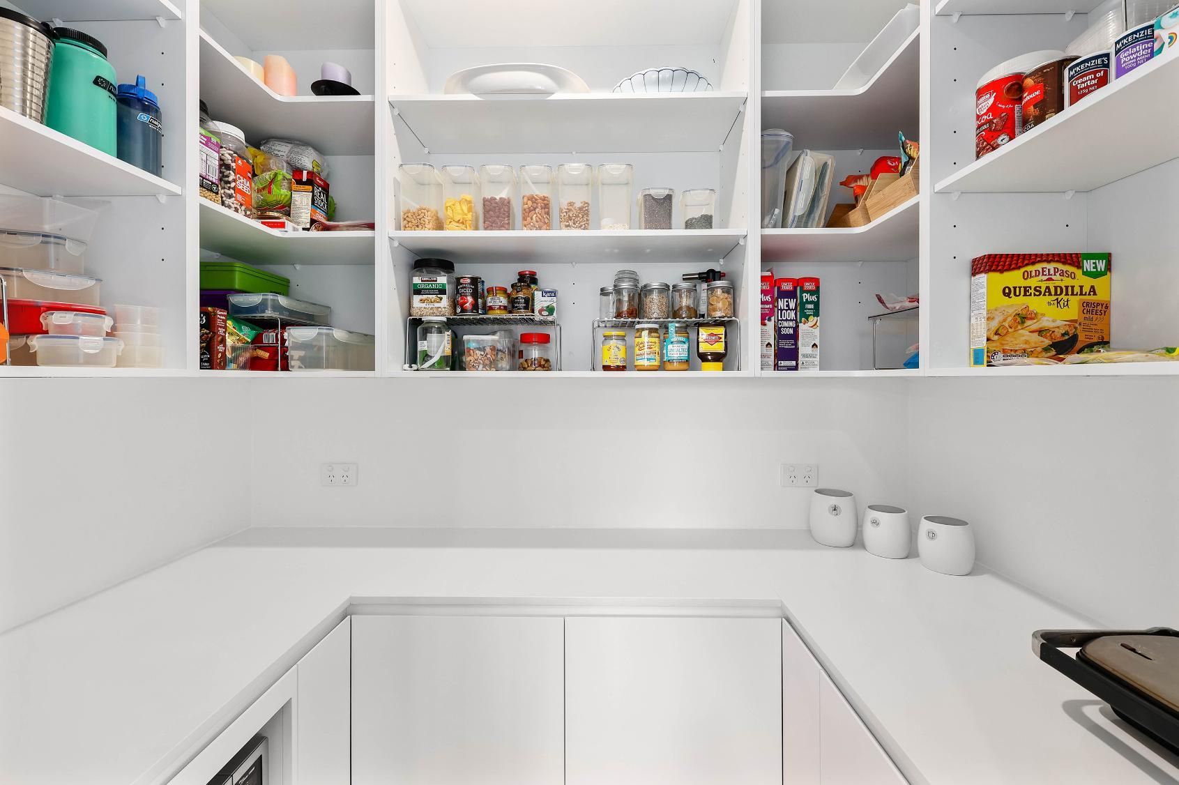 White Pantry with Shelves Filled with Food Items, Countertop and Cabinets — Above & Beyond Interiors Custom Joinery in Killara, NSW