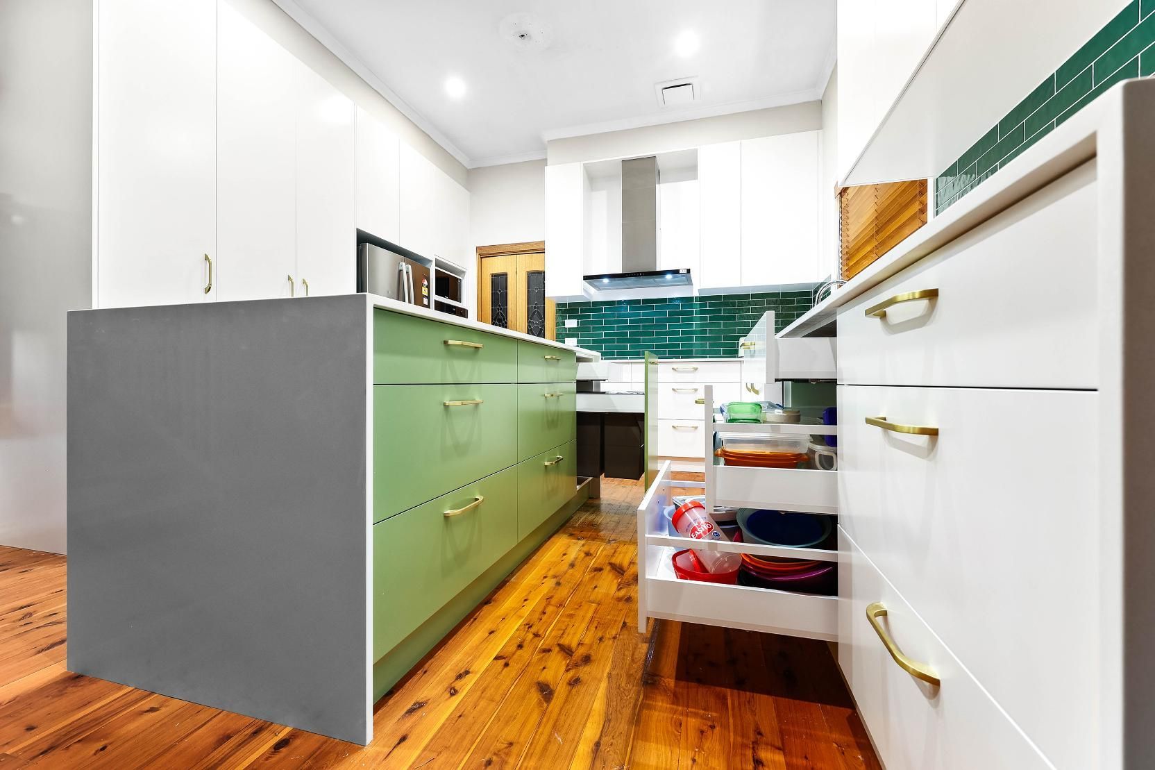 Kitchen with Green Island and White Cabinets; Wooden Floor — Above & Beyond Interiors Custom Joinery in Minto, NSW