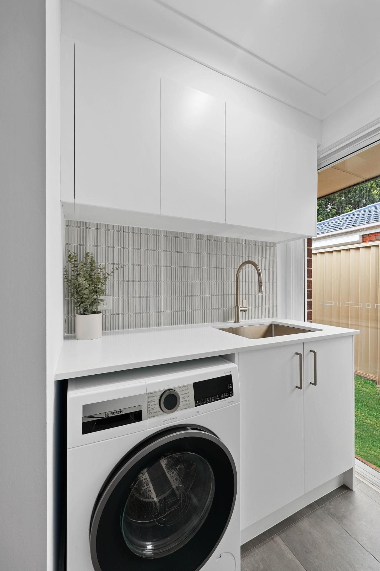 Modern White Laundry Room with Washer, Sink, and Cabinets — Above & Beyond Interiors Custom Joinery in Currans Hill, NSW
