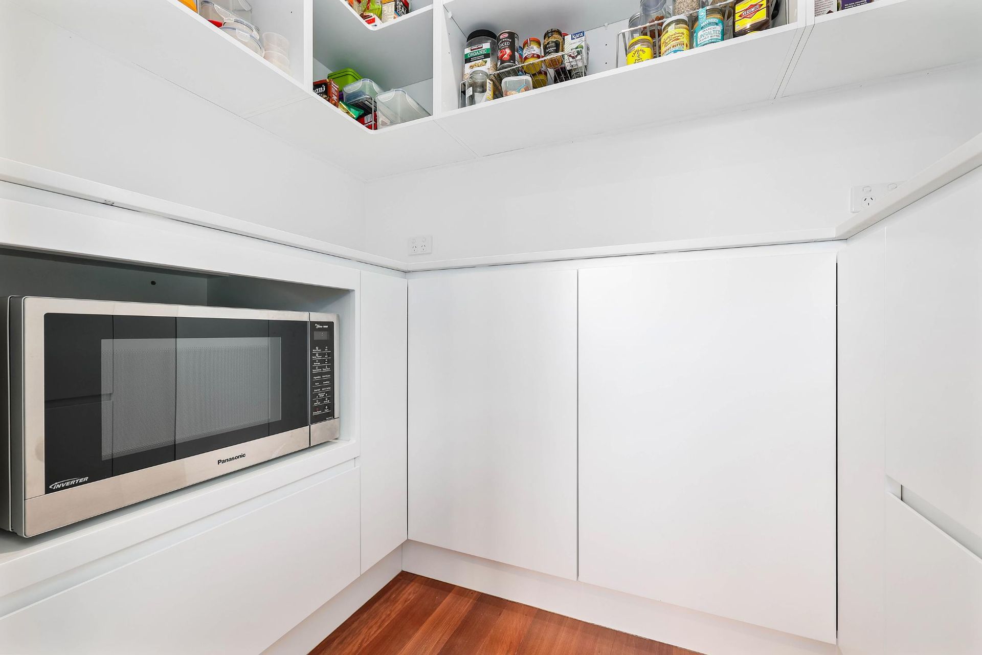 White Pantry with Microwave, Shelving, and Cabinets; Hardwood Floor — Above & Beyond Interiors Custom Joinery in Killara, NSW