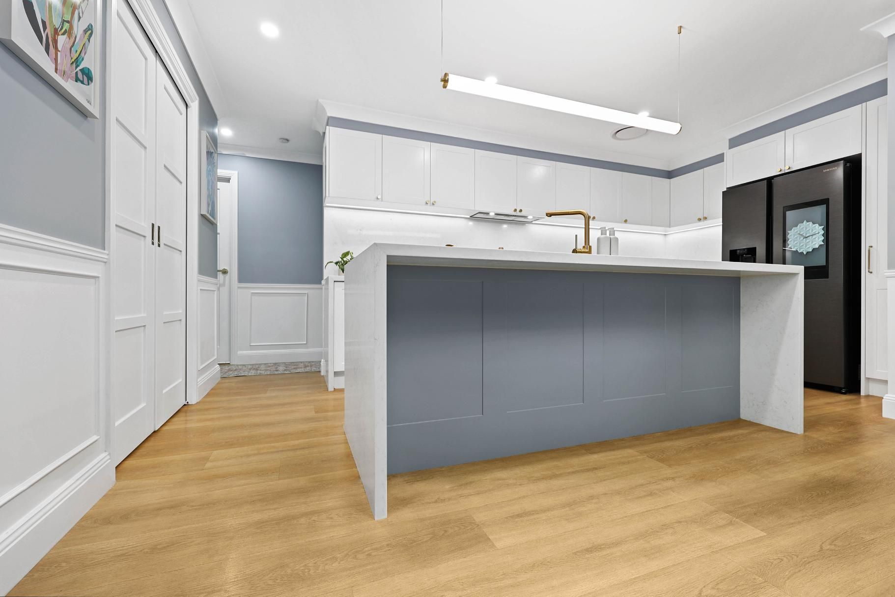 Modern Kitchen: Grey Island, White Cabinets, Wood Floors, Stainless Appliances, Blue Wall — Above & Beyond Interiors Custom Joinery in Harrington Park, NSW