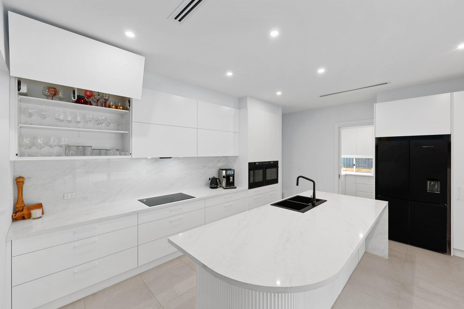 Modern White Kitchen with Island, Black Appliances, and Integrated Lighting — Above & Beyond Interiors Custom Joinery in Currans Hill, NSW