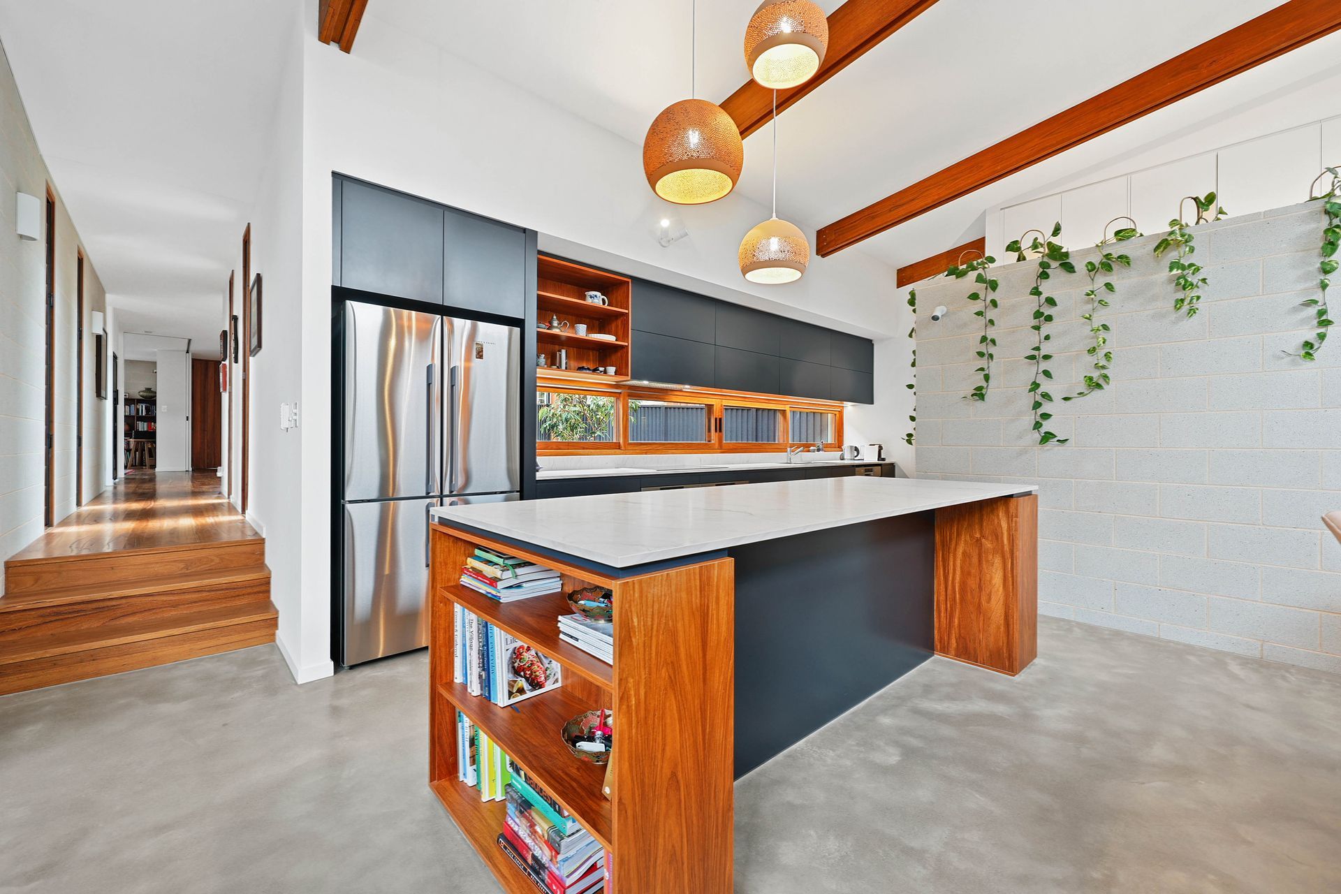 Modern kitchen with a grey island and cabinets, a white countertop, and wooden accents — Above & Beyond Interiors Custom Joinery in Bellambi, NSW