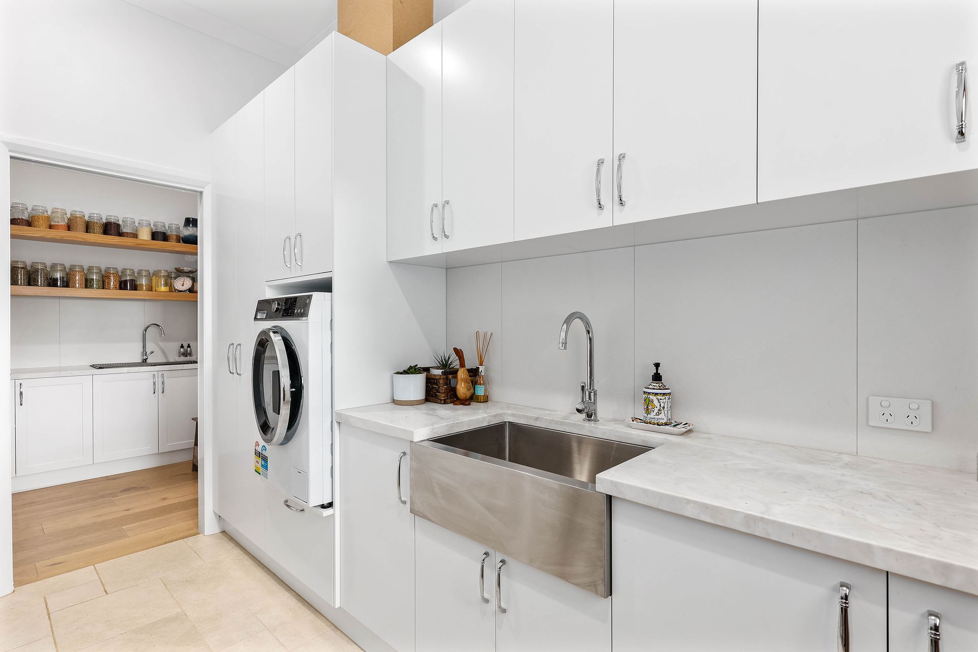 White laundry room with sink, cabinets, and a washing machine — Above & Beyond Interiors Custom Joinery in Bradbury, NSW