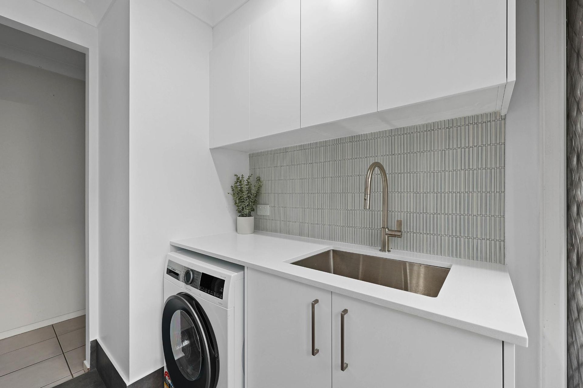 Modern White Laundry Room with A Washing Machine, Sink, and Overhead Cabinets — Above & Beyond Interiors Custom Joinery in Currans Hill, NSW