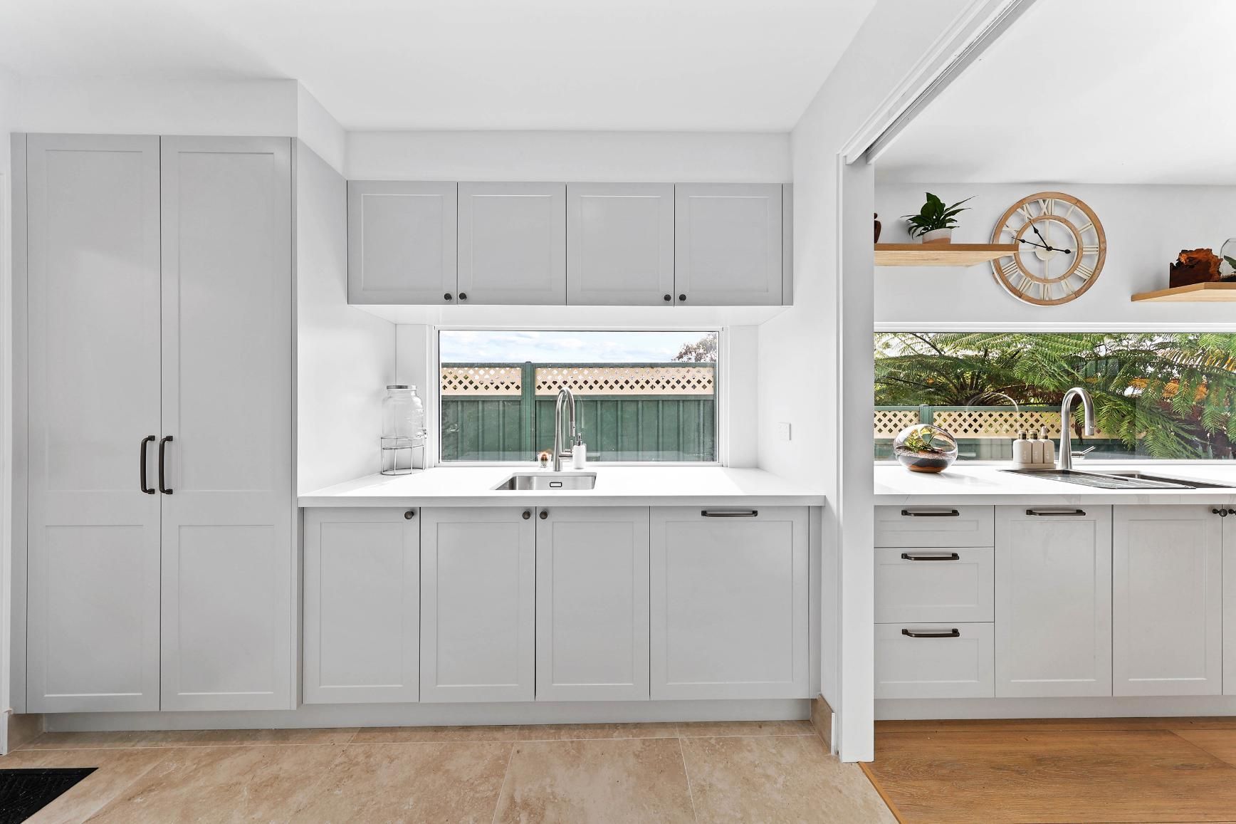 Light Grey Kitchen with Cabinets, Window Over a Sink, and Wooden Floors — Above & Beyond Interiors Custom Joinery in Yowie Bay, NSW