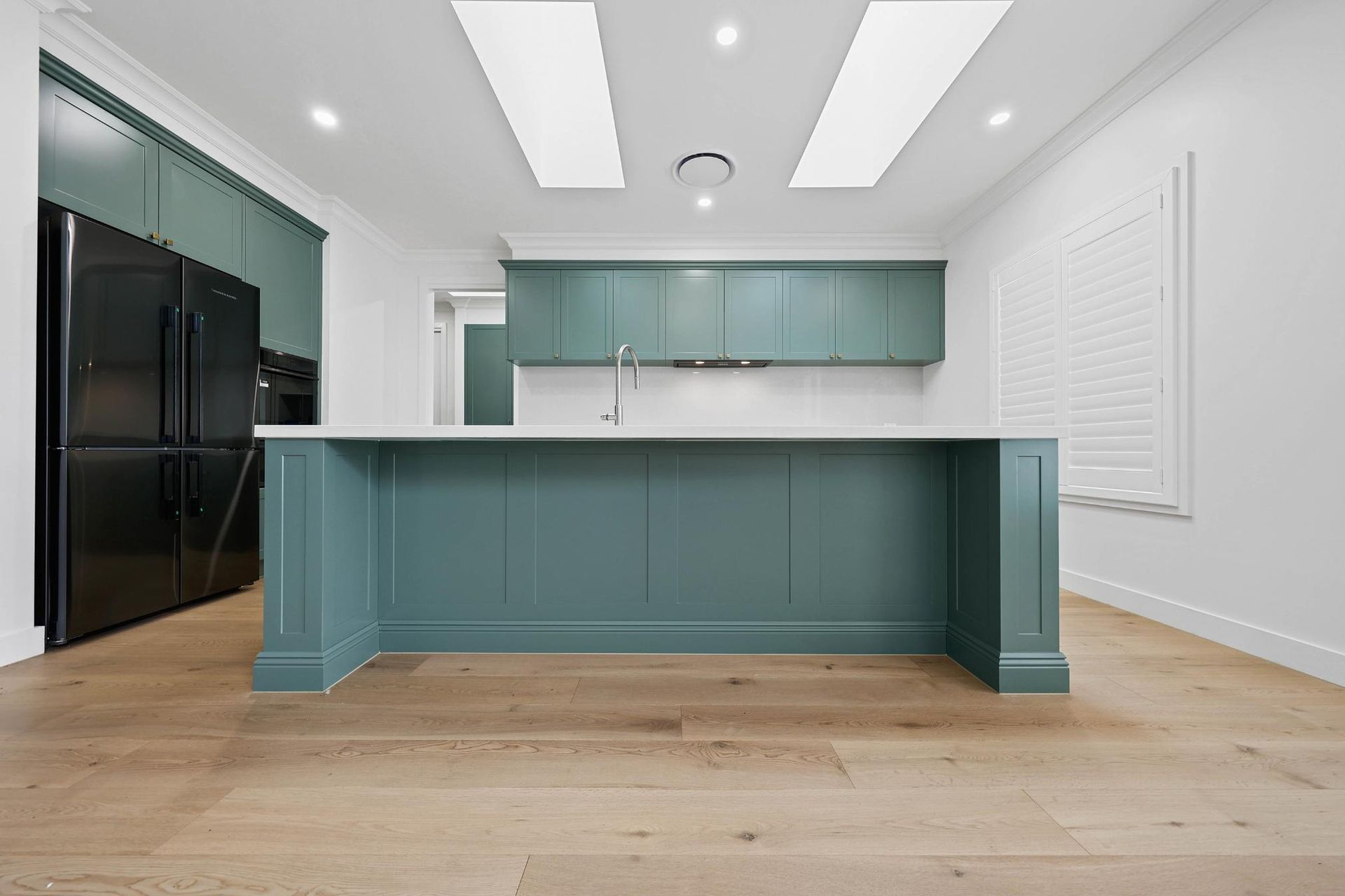 Modern Kitchen with Teal Cabinets, Large Black Fridge, and Wooden Floors — Above & Beyond Interiors Custom Joinery in Appin, NSW