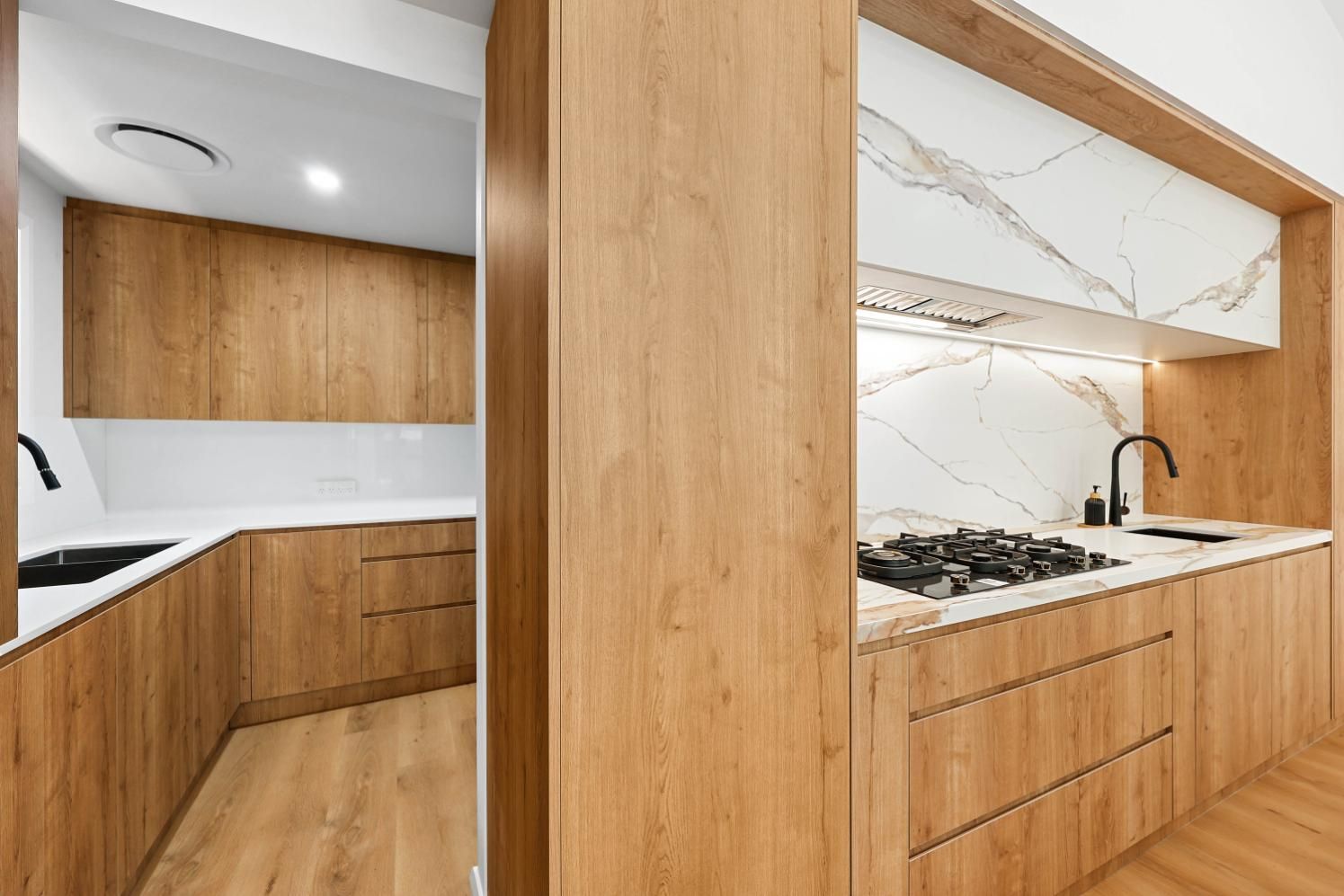 Modern Kitchen with Light Wood Cabinets, White Countertops, and Marble Backsplash — Above & Beyond Interiors Custom Joinery in Abbortsbury, NSW