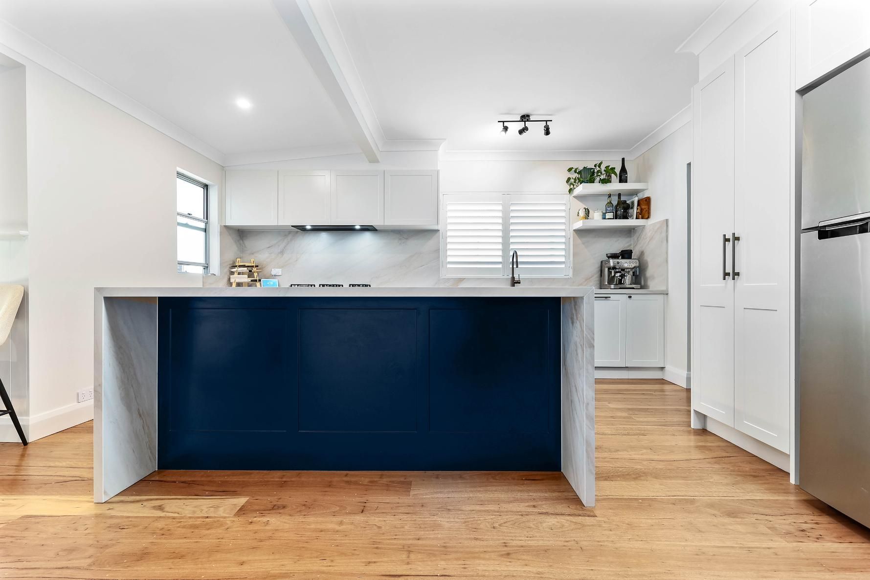 Modern Kitchen with A Blue Island, White Cabinets, and Wood Floors — Above & Beyond Interiors Custom Joinery in Bellambi, NSW