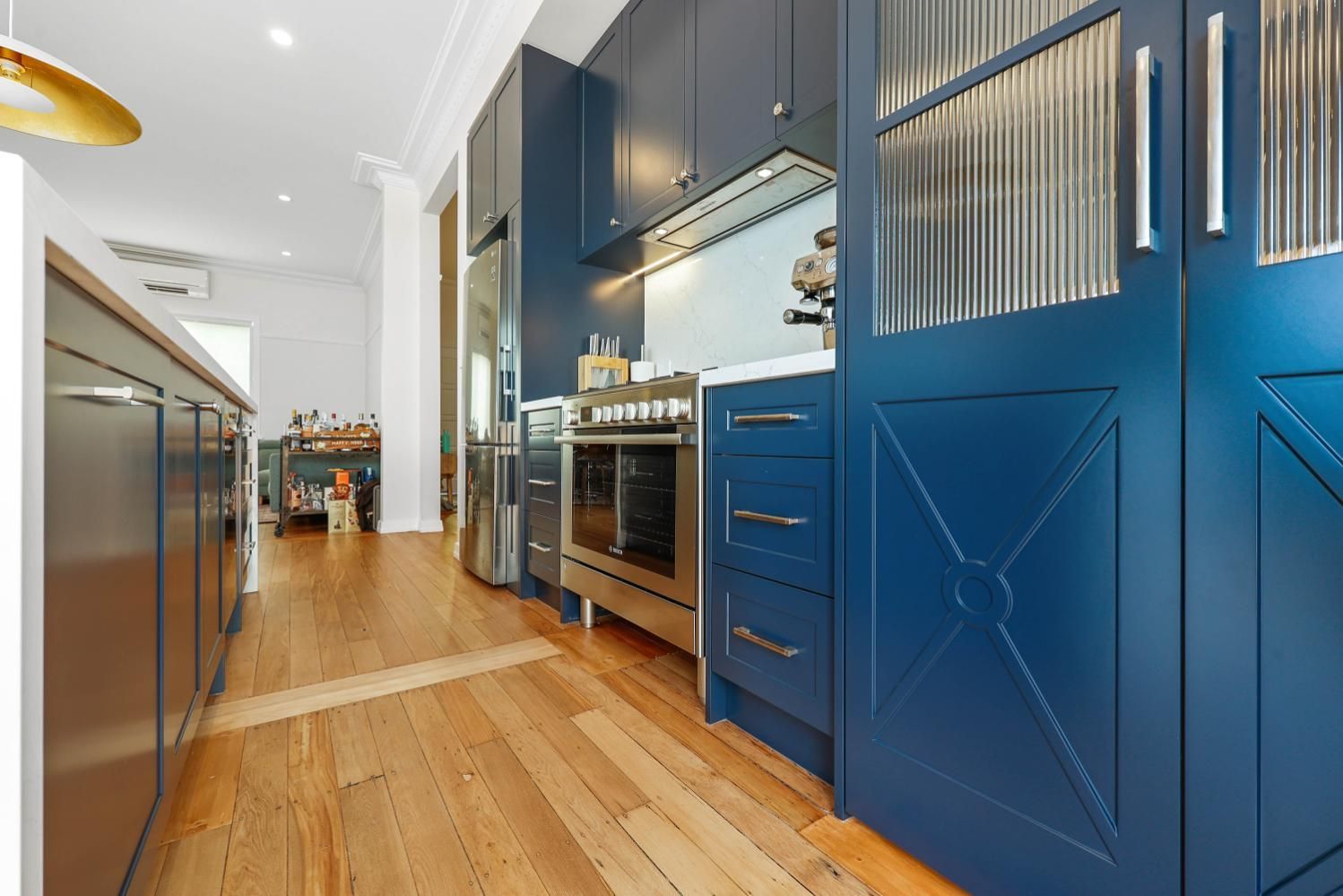 Blue Kitchen with Wood Floors and Stainless Steel Appliances — Above & Beyond Interiors Custom Joinery in Lilyfield, NSW