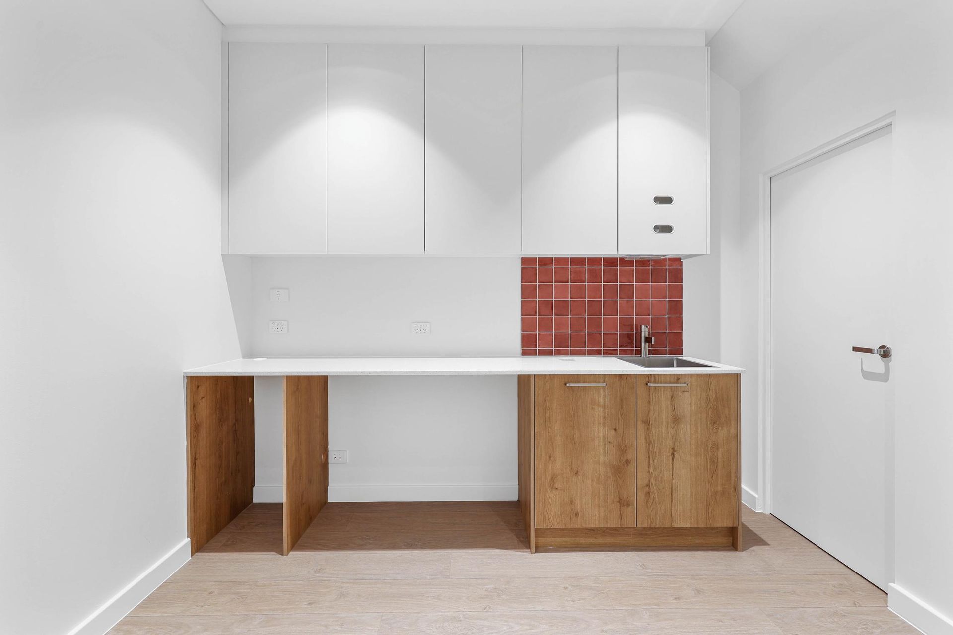 Laundry Room with White Cabinets, Wooden Accents, and A Red Tile Backsplash — Above & Beyond Interiors Custom Joinery in Medical Centre, NSW