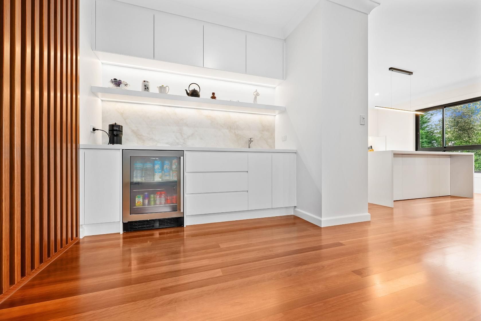 Modern White Bar Area with A Fridge, Wood Floors, and A Light-Colored Accent Wall — Above & Beyond Interiors Custom Joinery in Killara, NSW