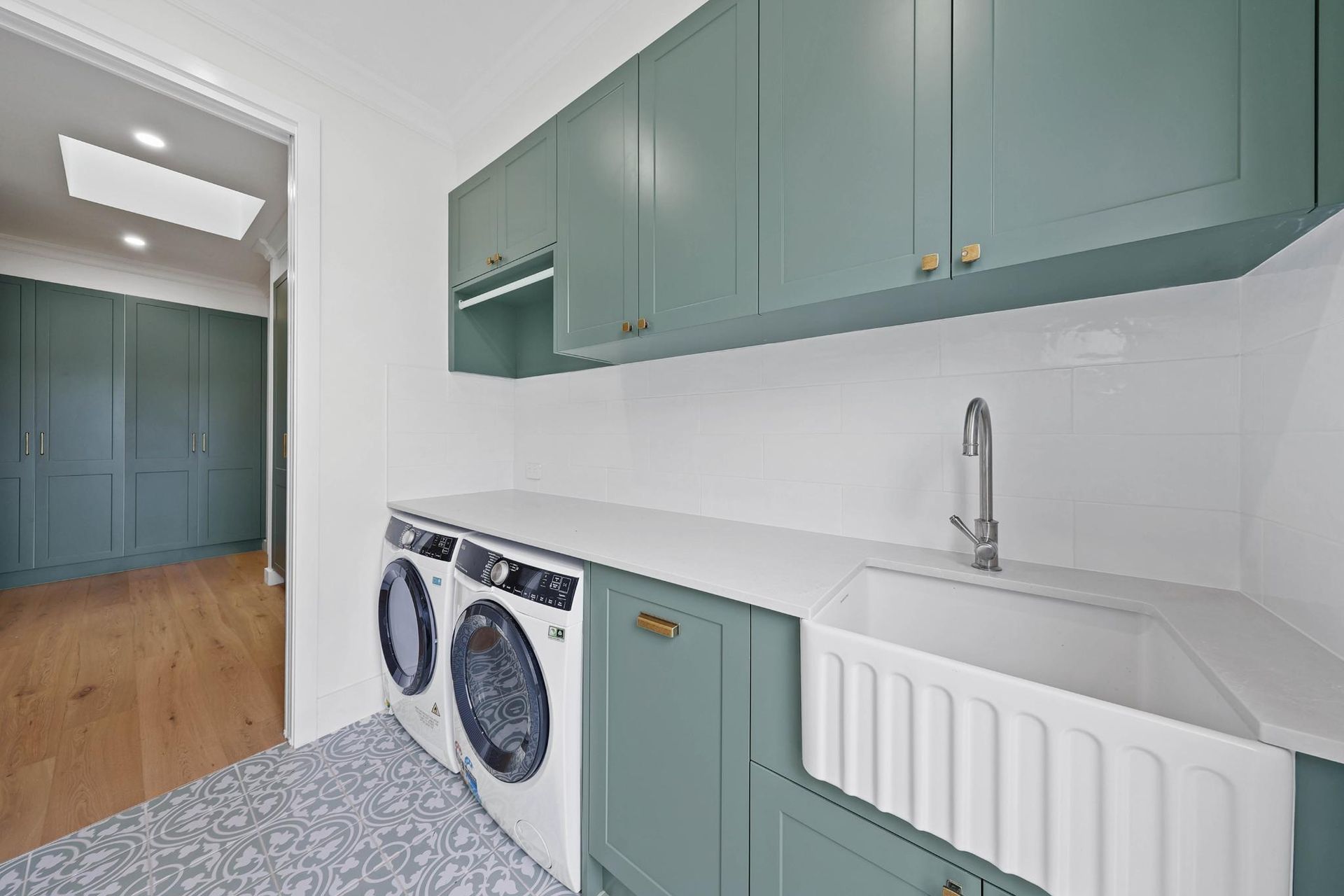 Laundry Room with Green Cabinets, White Countertop, and Washing Machine — Above & Beyond Interiors Custom Joinery in Appin, NSW