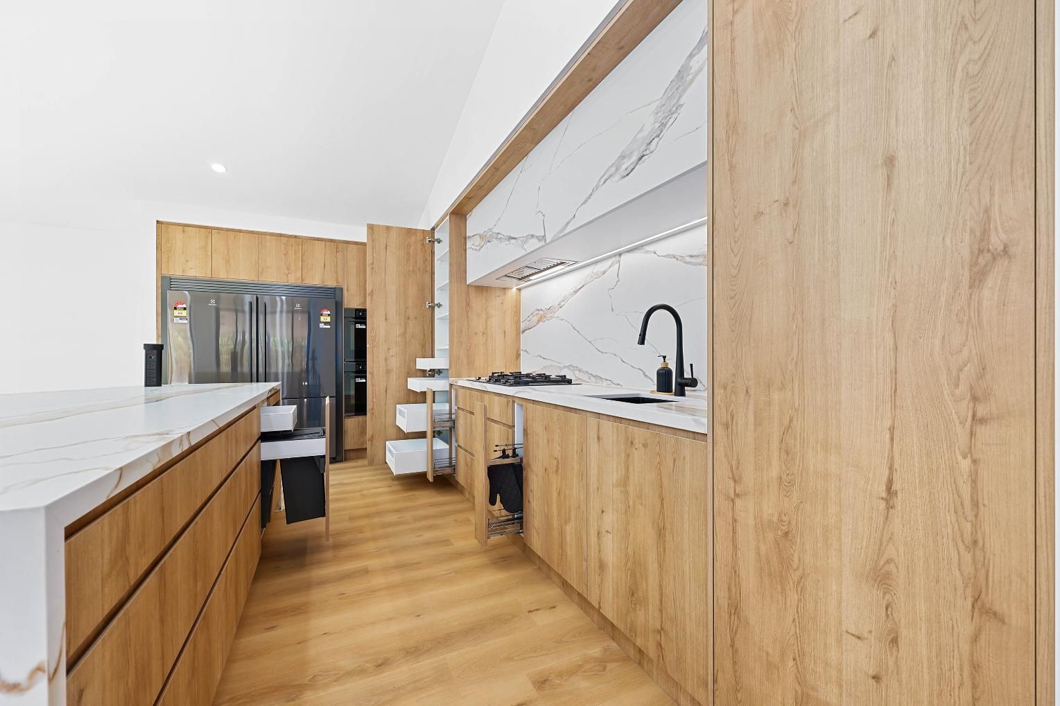 Modern Kitchen with Wood Cabinets, Marble Countertops, and A Black Faucet — Above & Beyond Interiors Custom Joinery in Abbortsbury, NSW