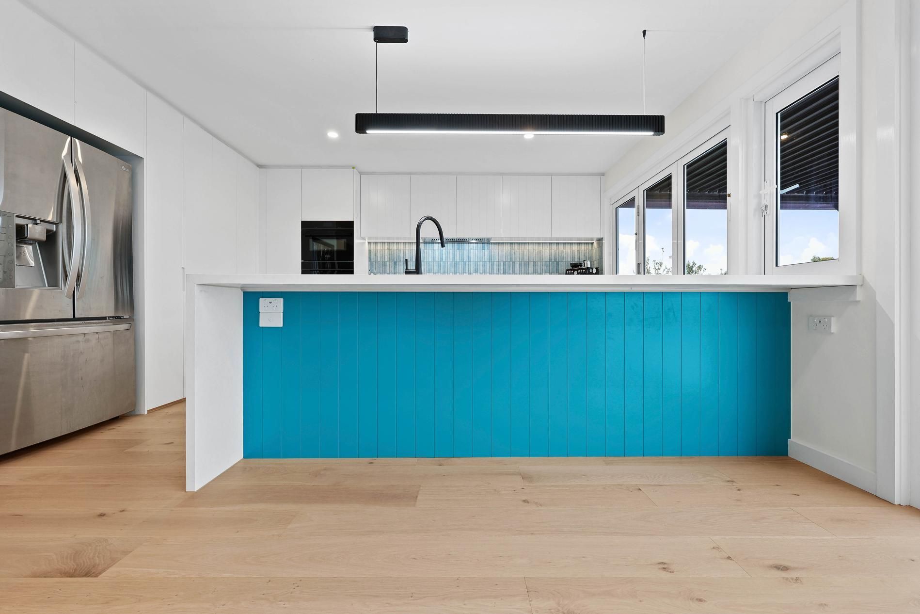 Modern Kitchen with A Turquoise Island, White Cabinets, and Stainless Steel Appliances — Above & Beyond Interiors Custom Joinery in North Curl Curl, NSW