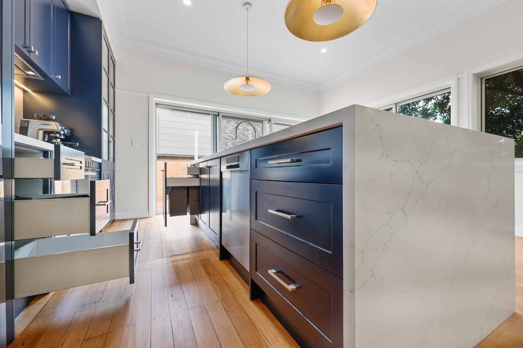 Modern Kitchen with Navy Blue Cabinets, Wood Floors, and Concrete Island — Above & Beyond Interiors Custom Joinery in Lilyfield, NSW