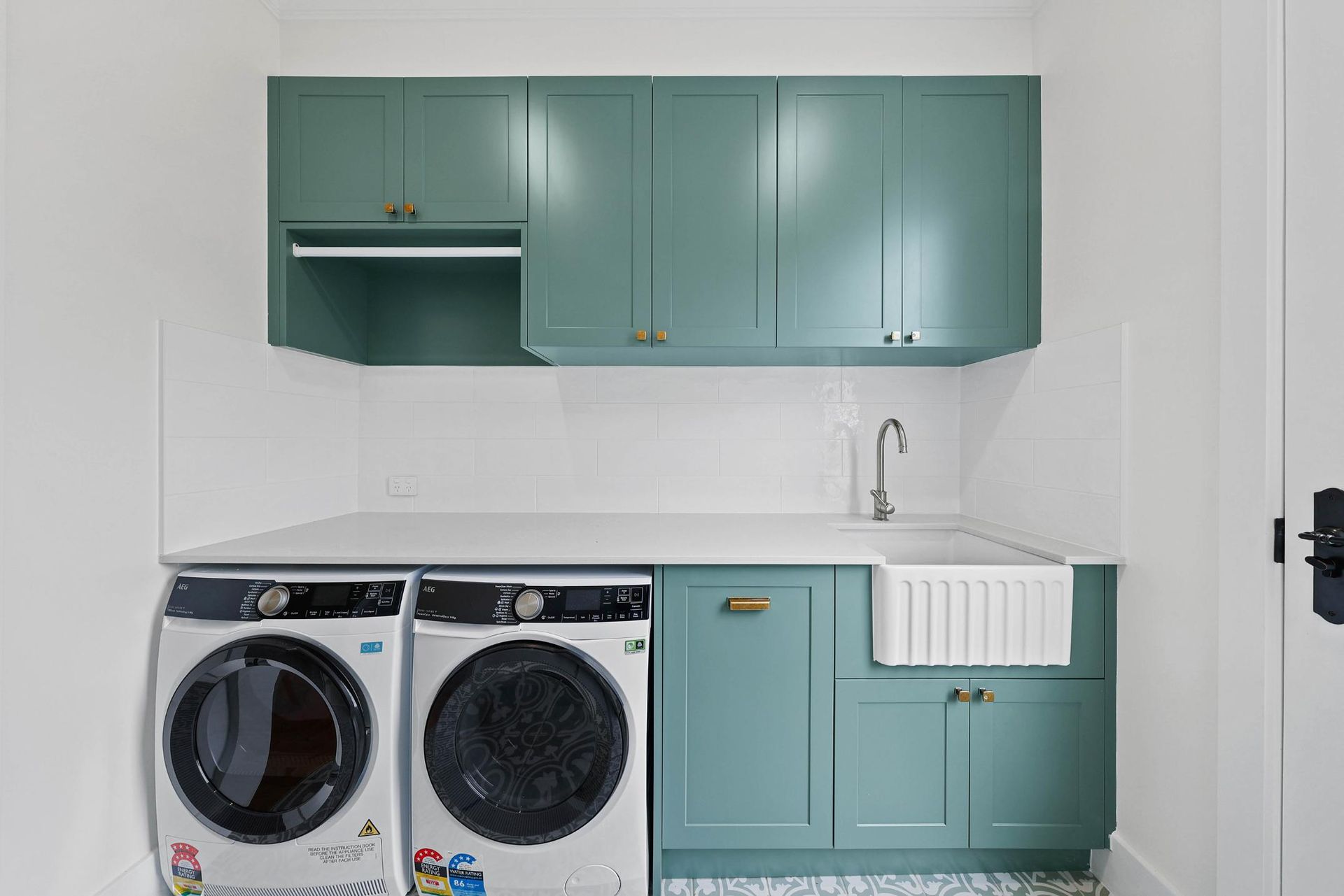 Laundry Room with Green Cabinets, White Countertop, and Washer/dryer — Above & Beyond Interiors Custom Joinery in Appin, NSW