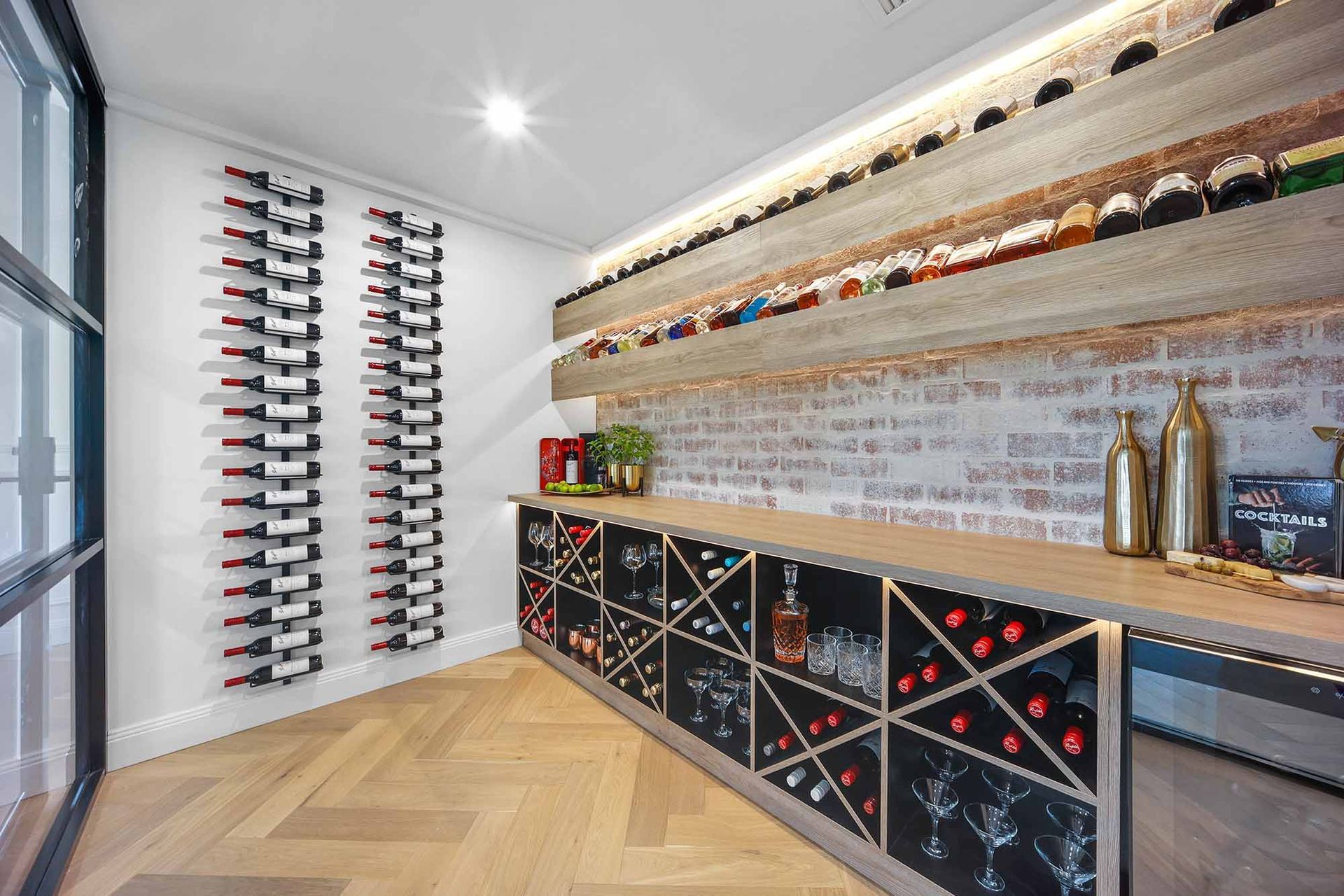 Wine cellar with brick wall, wooden shelves, and wine racks — Above & Beyond Interiors Custom Joinery in Bellambi, NSW