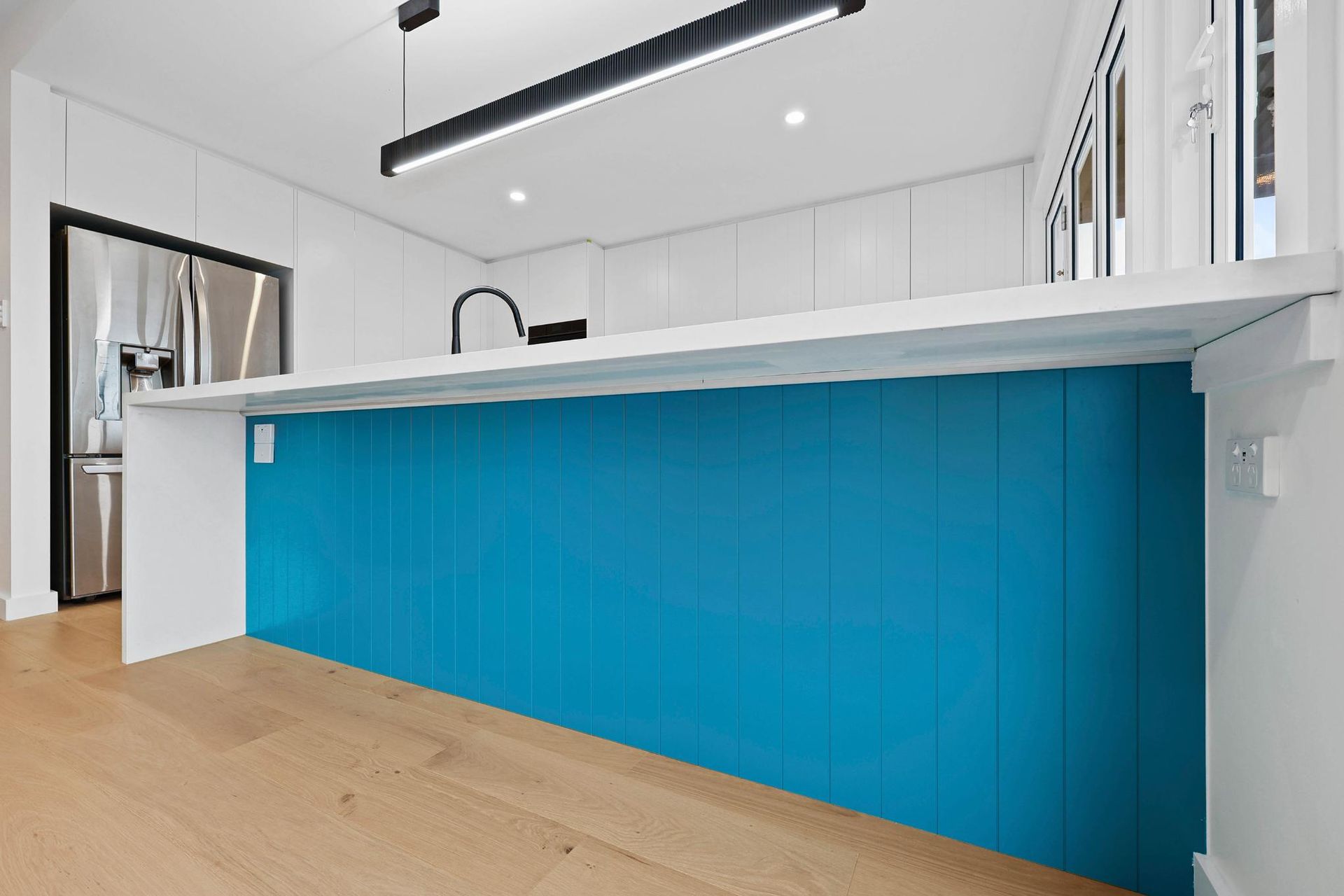 Modern Kitchen Island with A Turquoise Panel and White Countertop — Above & Beyond Interiors Custom Joinery in North Curl Curl, NSW