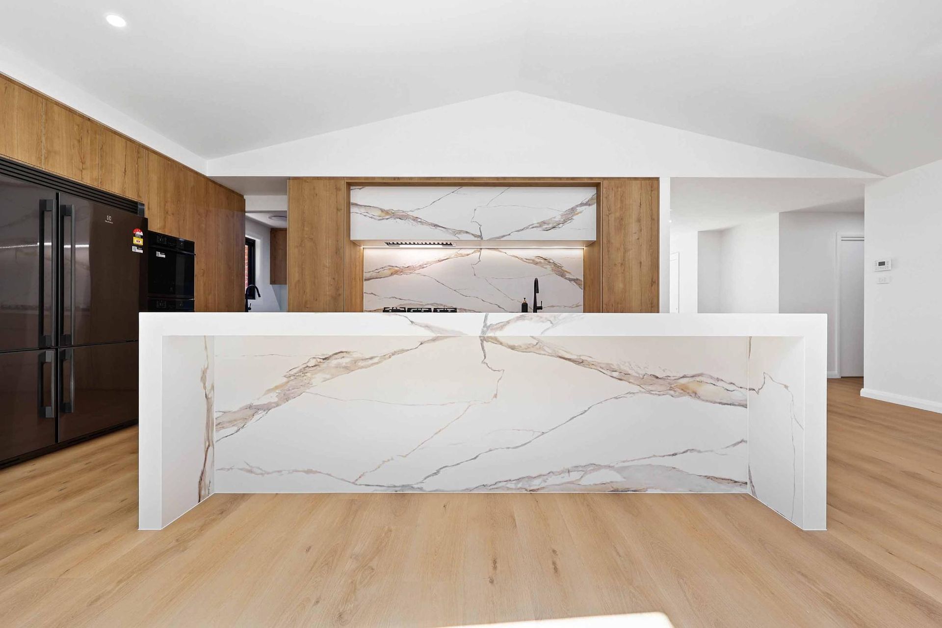 Modern Kitchen with White Countertops, Wood Accents, and A Large Island — Above & Beyond Interiors Custom Joinery in Abbortsbury, NSW