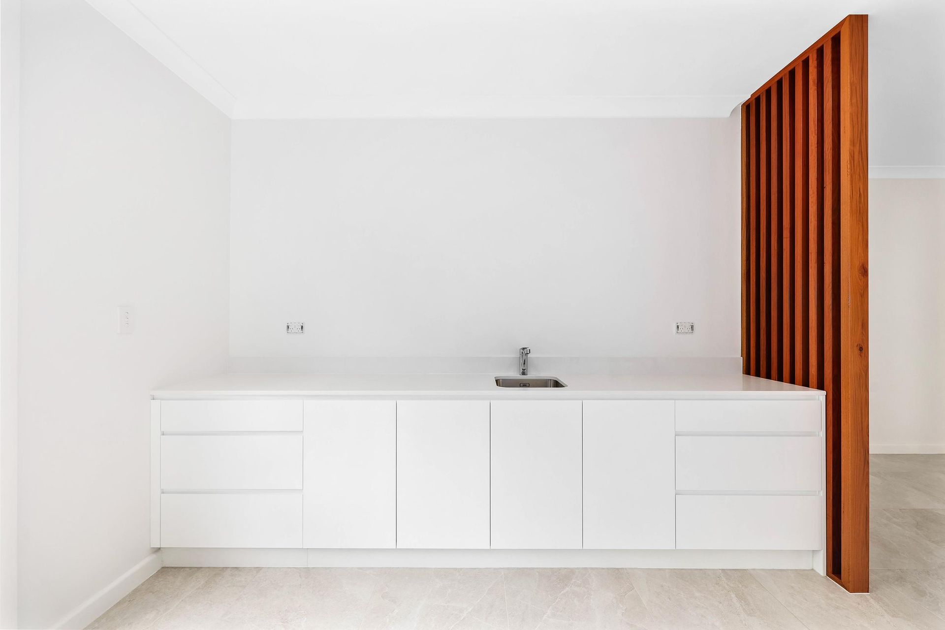 White Cabinetry with A Sink, Against a White Wall. a Wooden Slat Partition Is on The Right — Above & Beyond Interiors Custom Joinery in Killara, NSW