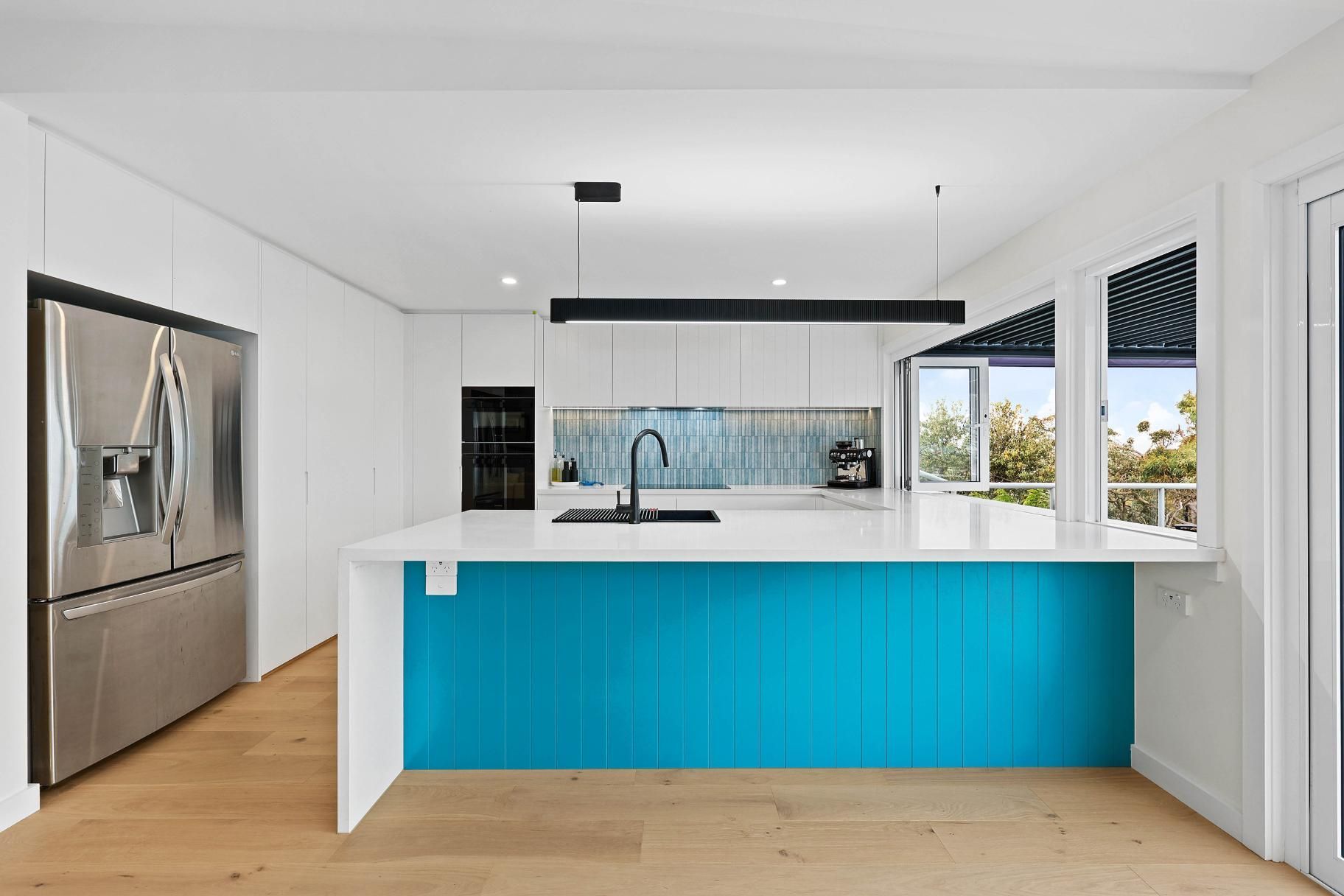 Modern Kitchen with White Cabinets, a Blue Island, and A Stainless Steel Refrigerator — Above & Beyond Interiors Custom Joinery in North Curl Curl, NSW