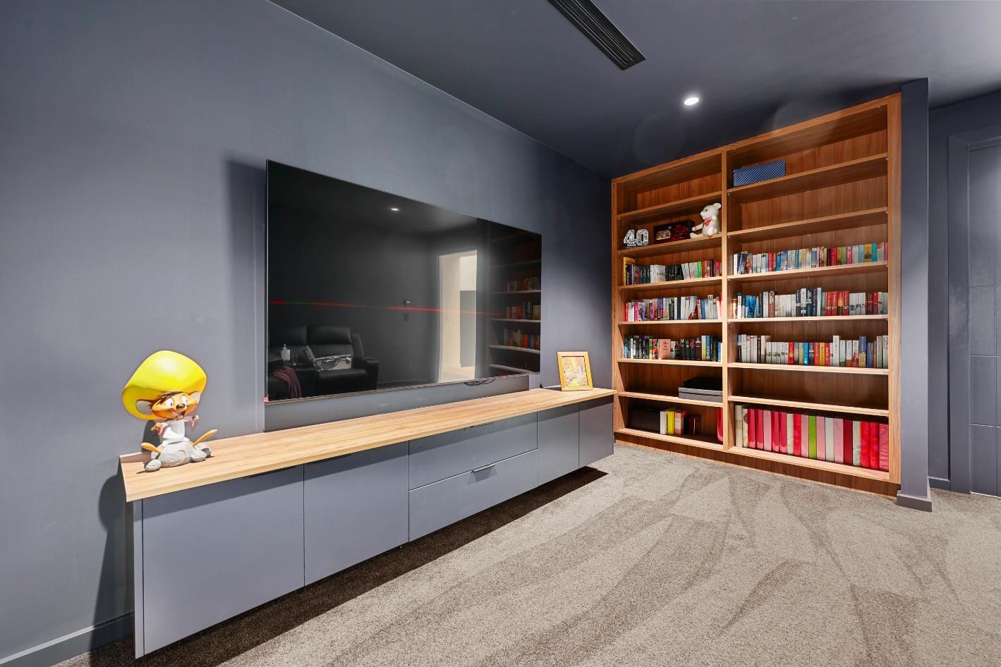 Modern Media Room with Grey Walls, a Large Tv, Built-In Bookcase, and A Floating Cabinet — Above & Beyond Interiors Custom Joinery in Currans Hill, NSW