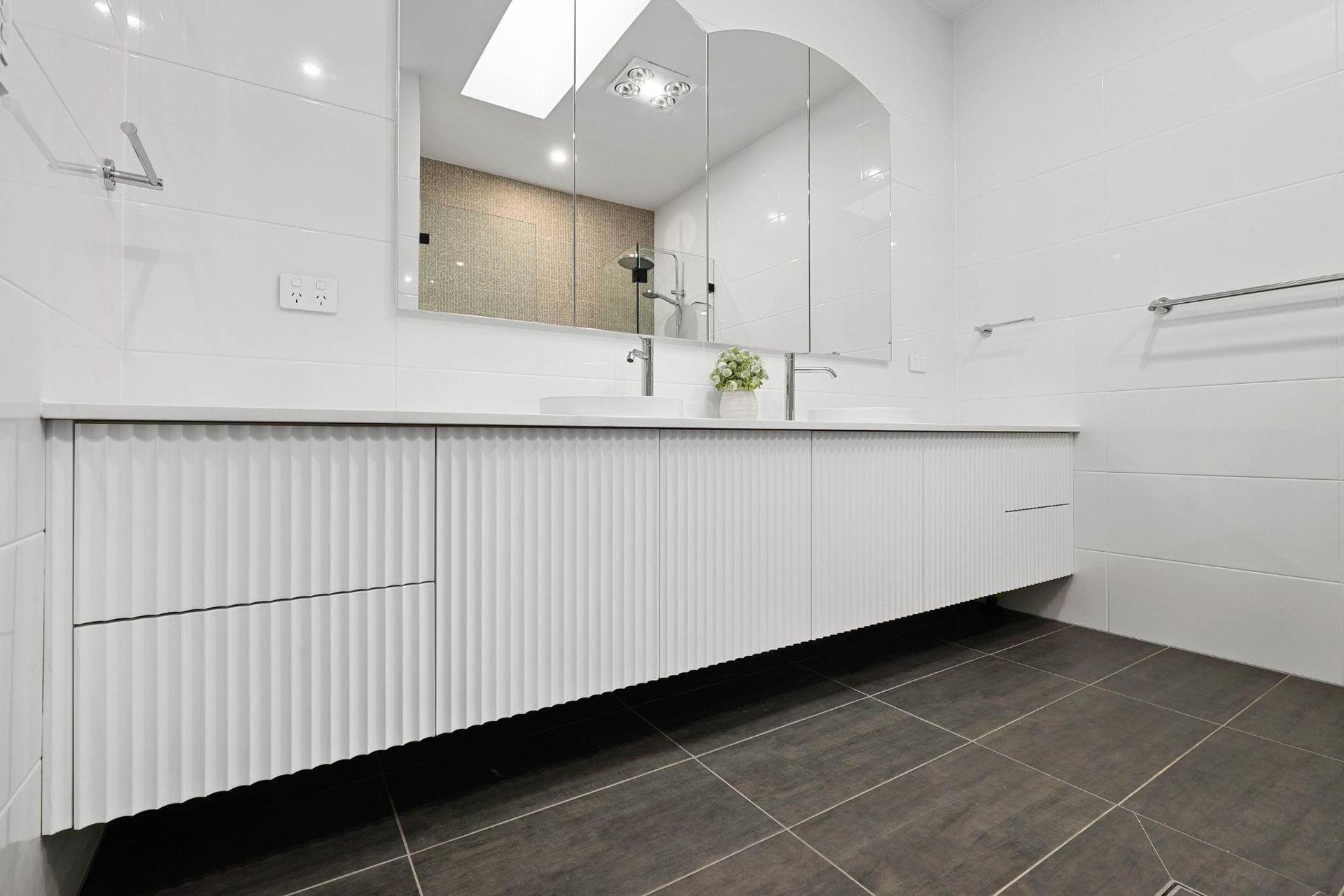 Modern White Bathroom with Floating Vanity, Dual Sinks, and Dark Grey Floor Tiles — Above & Beyond Interiors Custom Joinery in Currans Hill, NSW