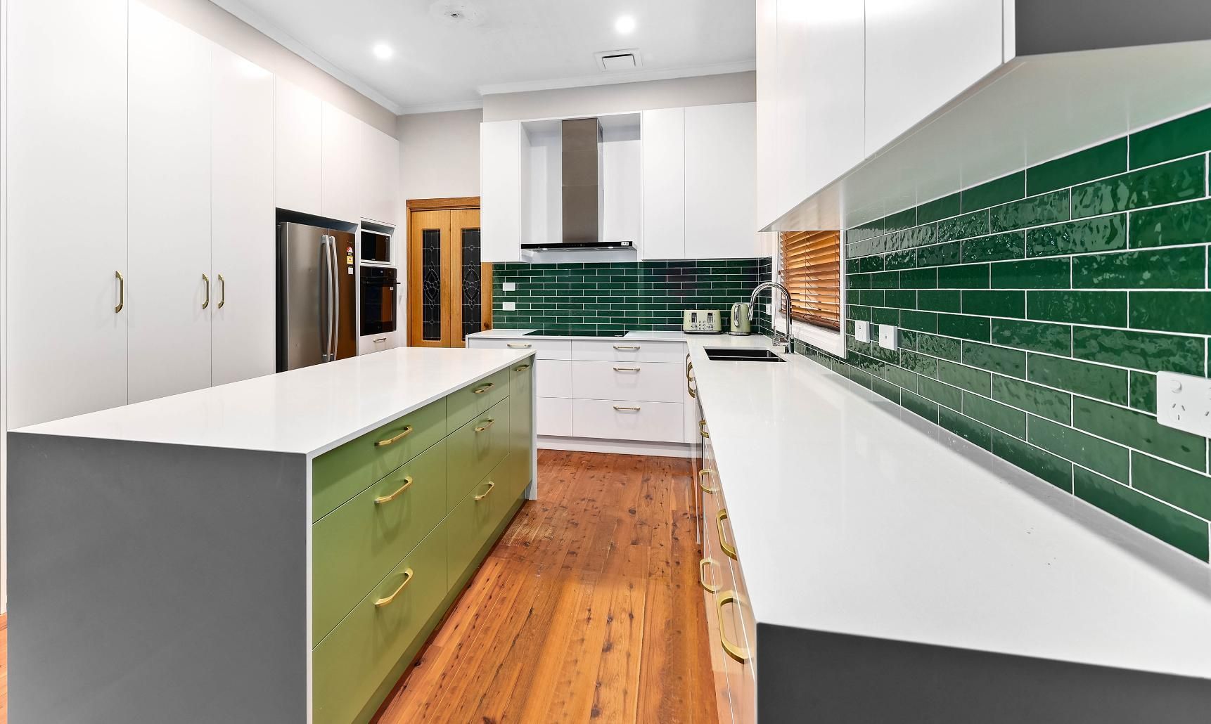 Green and White Kitchen with Island and Backsplash, Wooden Floor — Above & Beyond Interiors Custom Joinery in Minto, NSW