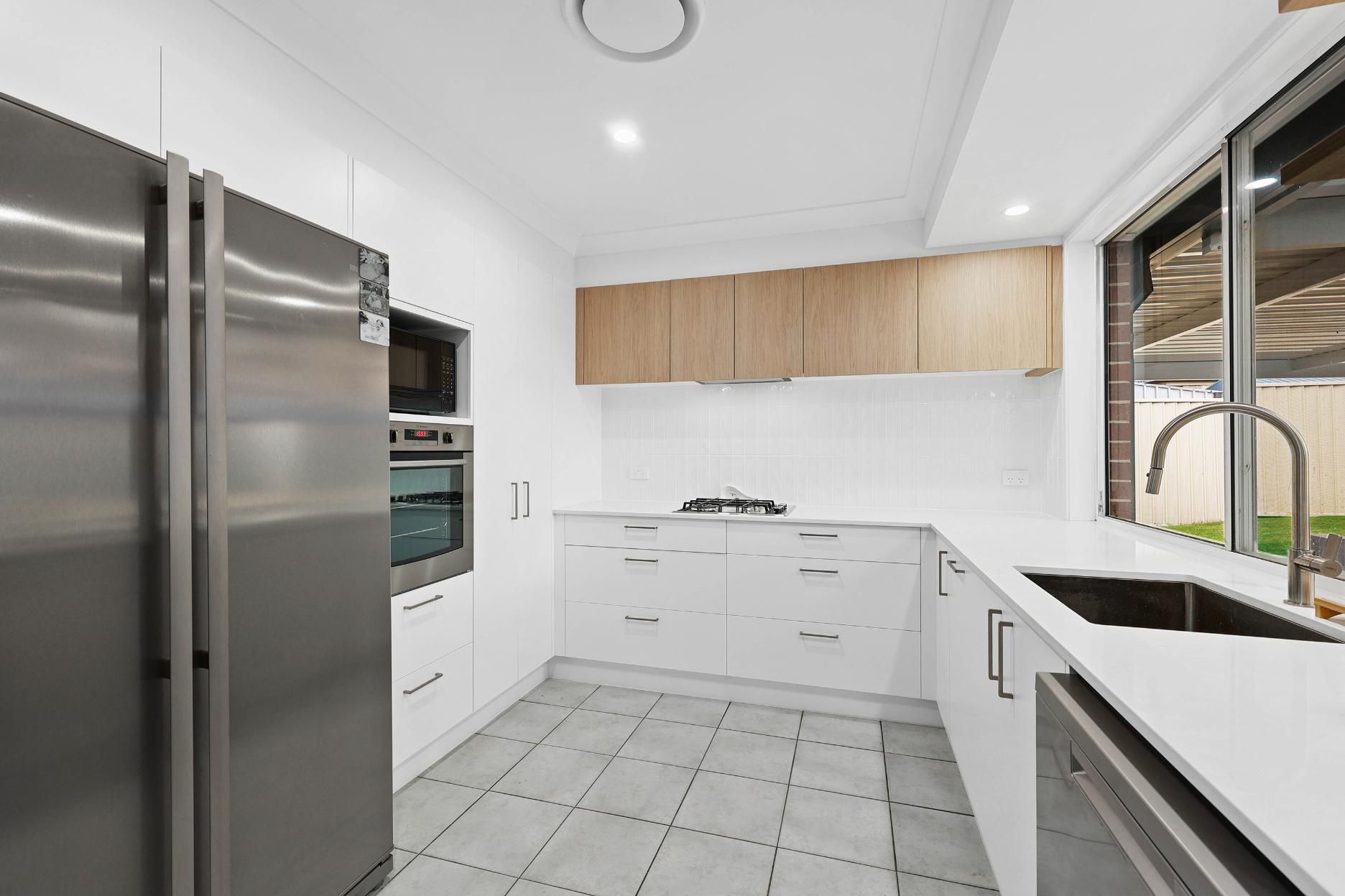 Modern, Bright Kitchen with Stainless Steel Appliances, White Cabinets, and Light Wood Upper Cabinets — Above & Beyond Interiors Custom Joinery in Currans Hill, NSW