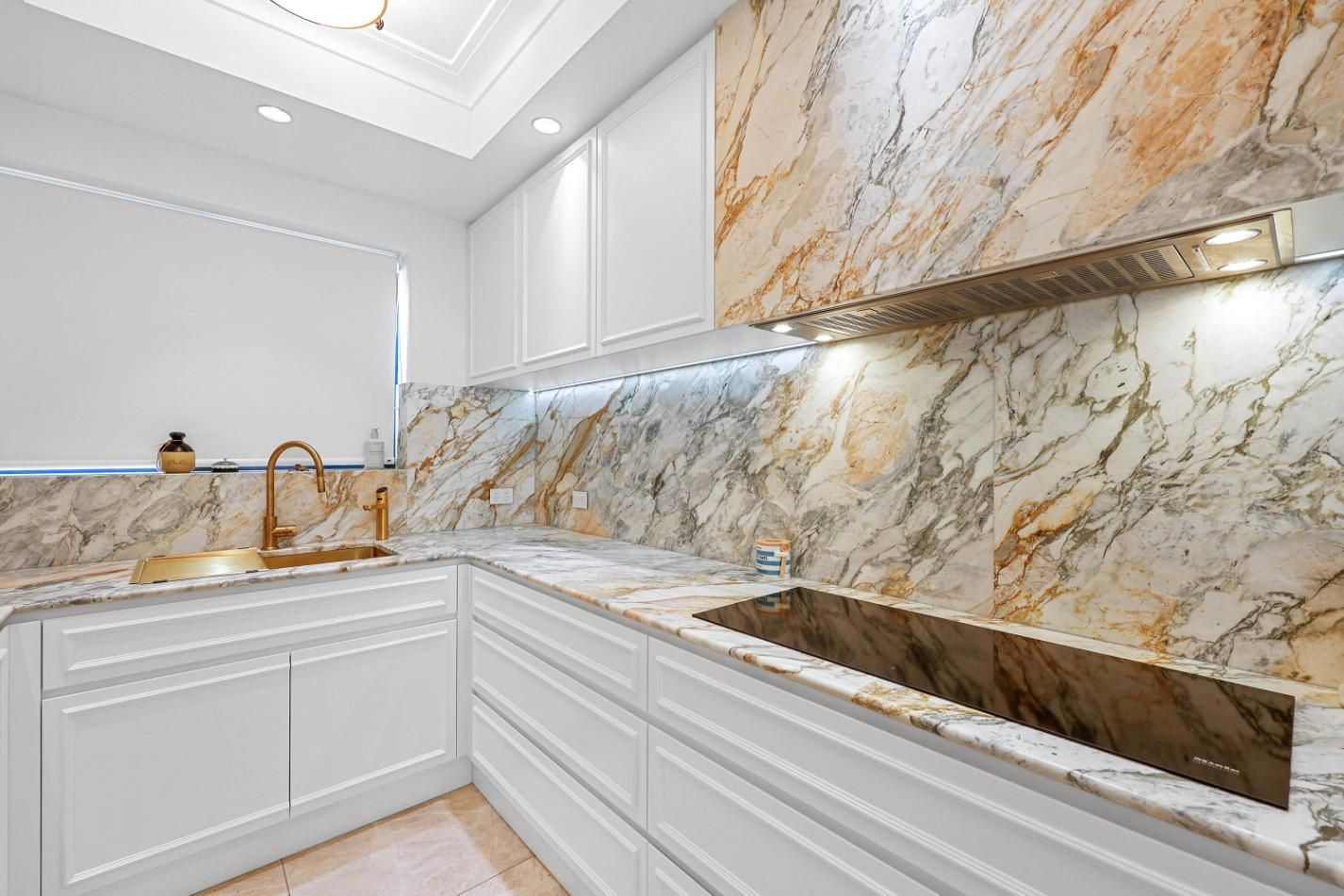 Elegant White Kitchen with Marble Countertops and Backsplash, Light Fixtures, and Built-In Oven — Above & Beyond Interiors Custom Joinery in Double Bay, NSW