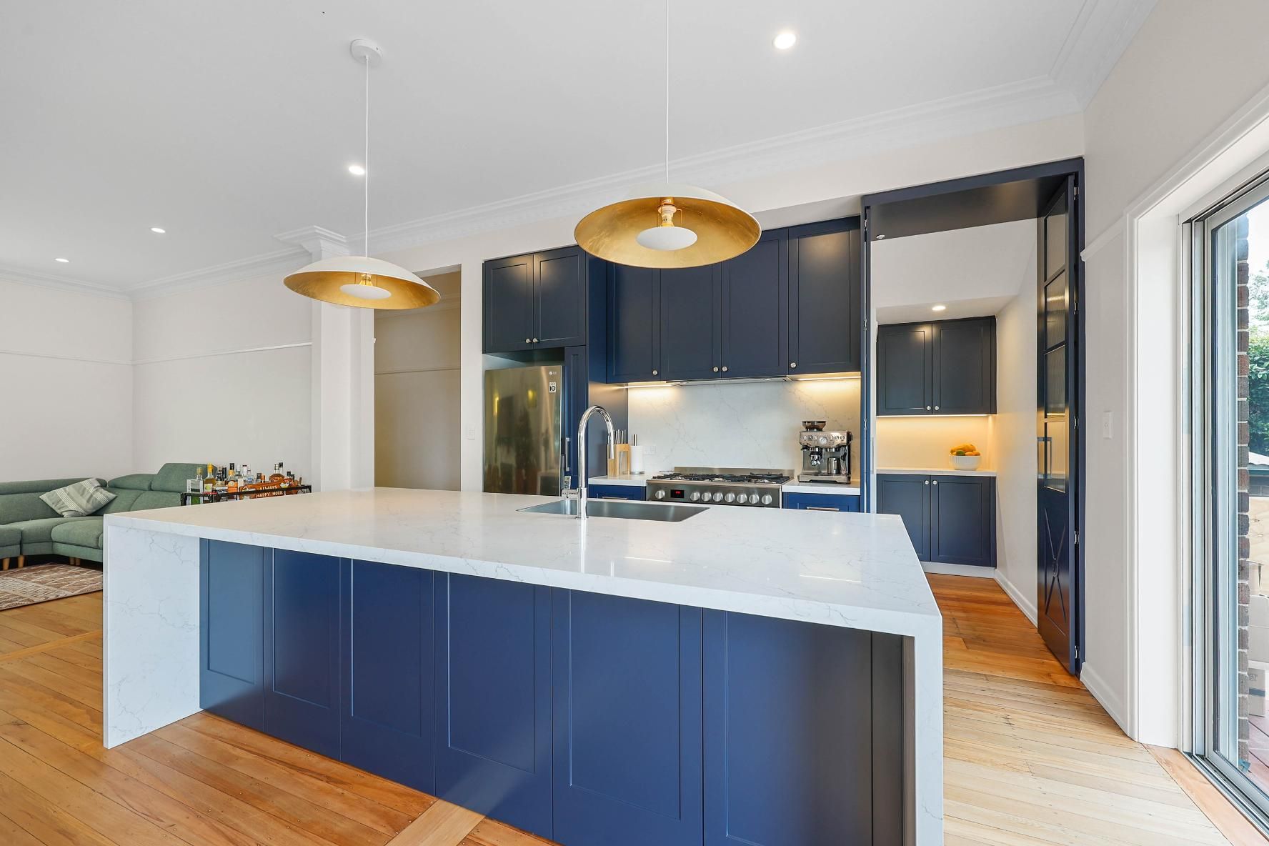 Modern Kitchen with Blue Cabinets, White Island, and Gold Pendant Lights — Above & Beyond Interiors Custom Joinery in Lilyfield, NSW