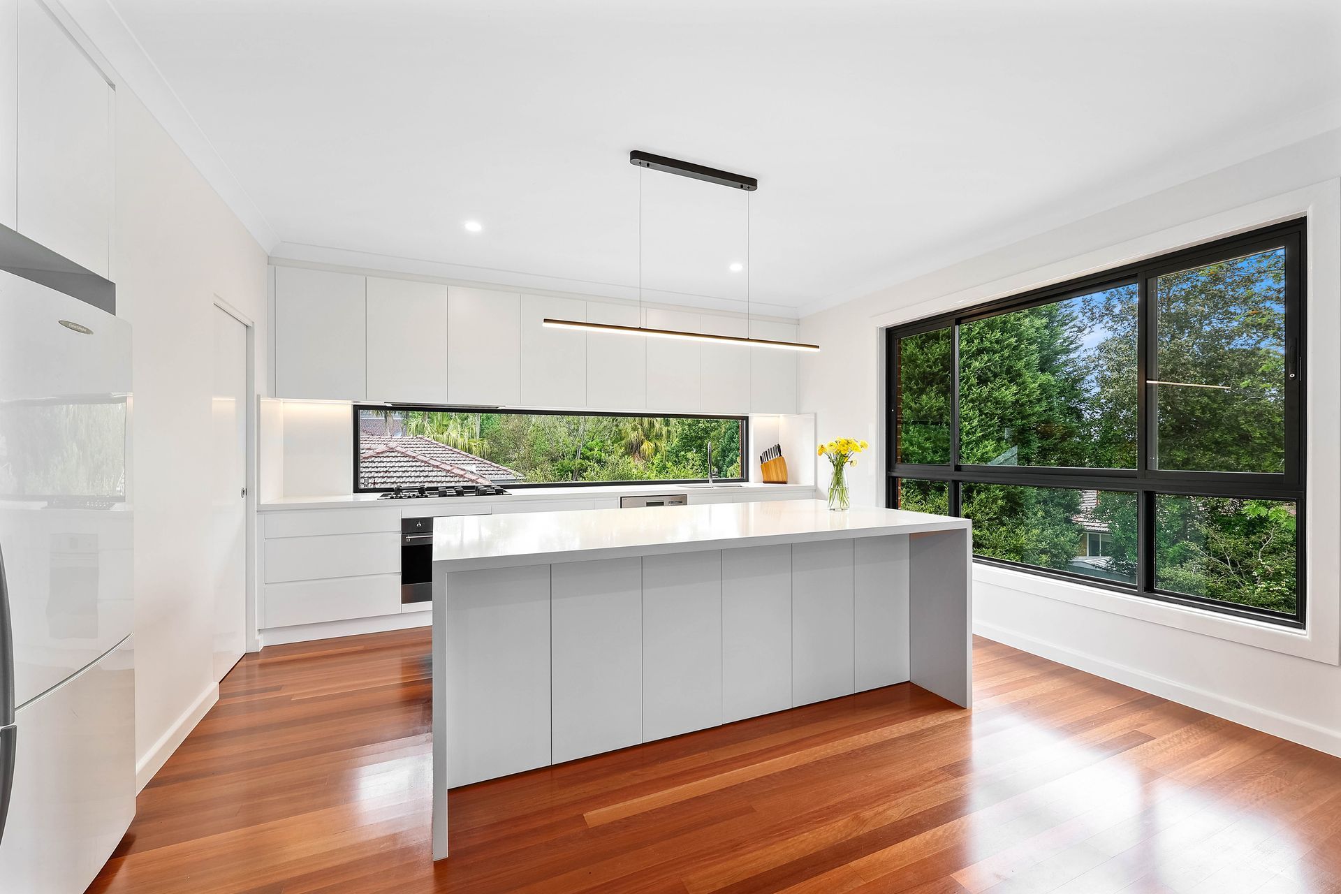 A Kitchen with White Cabinets and A Large Island — Above & Beyond Interiors in Smeaton Grange, NSW