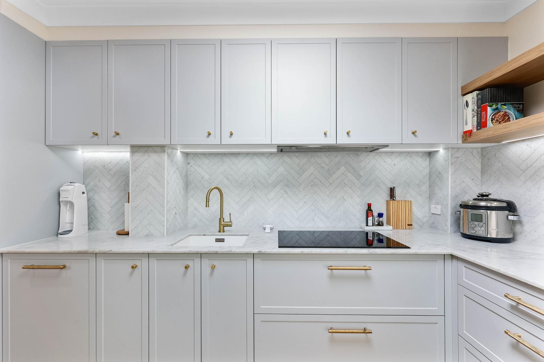 Light Grey Kitchen Cabinets, White Countertops, Gold Hardware, and A Herringbone Backsplash — Above & Beyond Interiors Custom Joinery in Erskineville, NSW