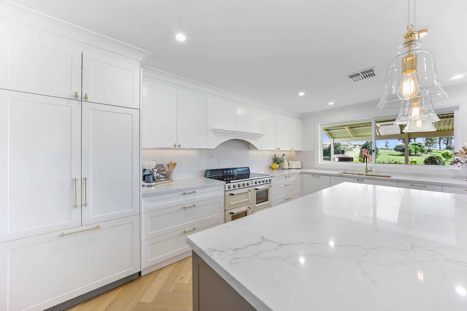 Bright, modern kitchen with white cabinets, marble countertops, and a large island — Above & Beyond Interiors Custom Joinery in Bellambi, NSW