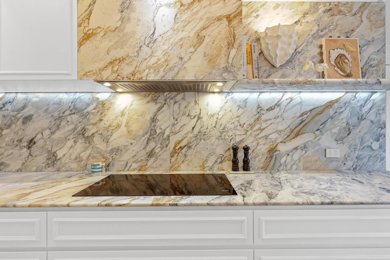 Kitchen with White Cabinets, Granite Countertops and Backsplash; a Range Hood and A Cooktop — Above & Beyond Interiors Custom Joinery in Double Bay, NSW