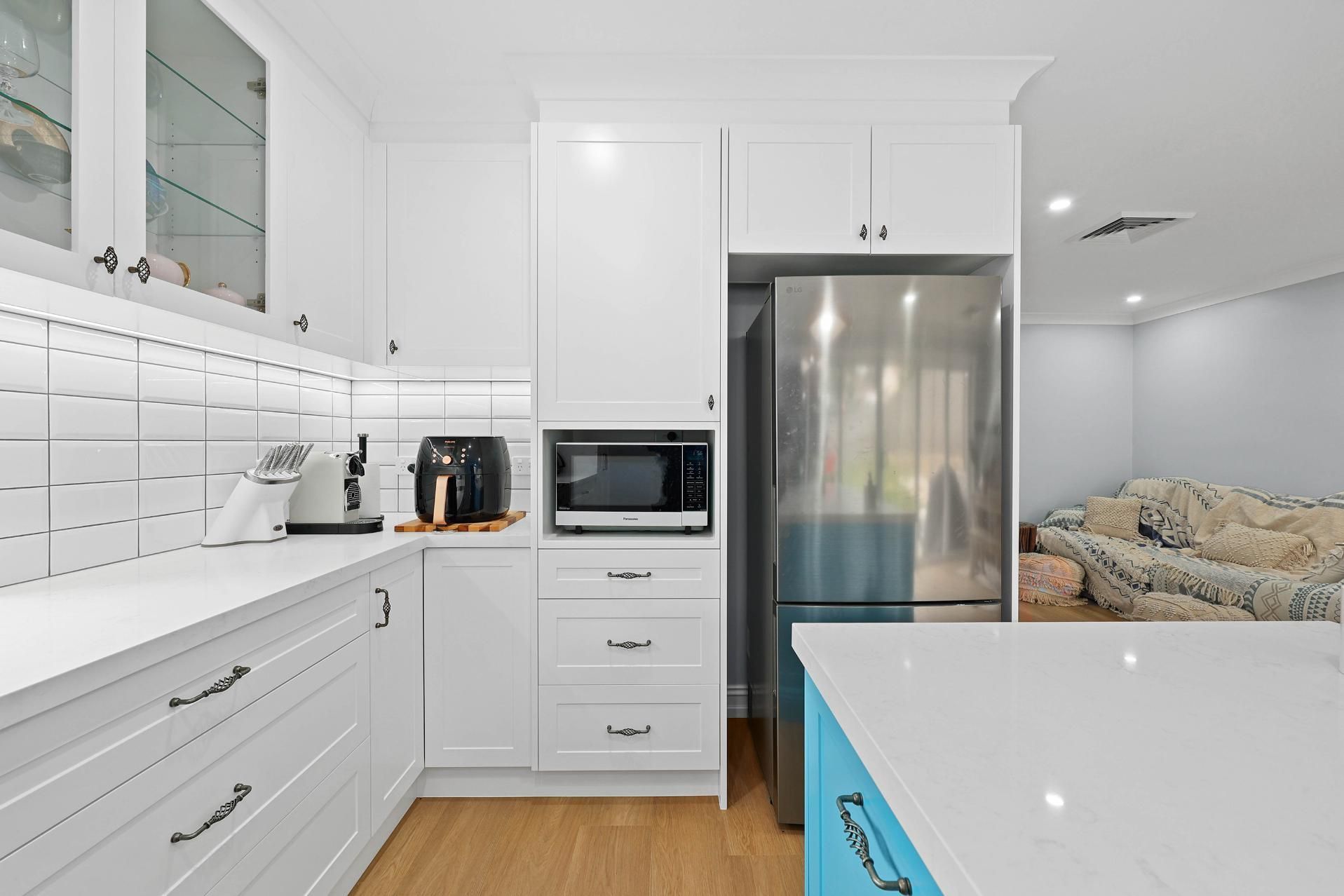 White Kitchen with Island, Stainless Fridge, Microwave, and Oven — Above & Beyond Interiors Custom Joinery in Gladsville, NSW